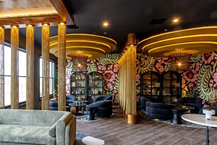 Gustavo's -Modern lounge interior featuring a custom wood ceiling lighting housing that frames a sculptural art installation with layered beading, creating a focal point above the space and highlighting detailed craftsmanship and decorative artistry.