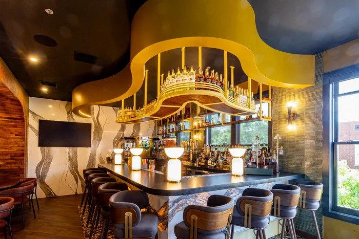 Gustavo's Mexican Grill - Louisville KY - Modern bar interior highlighting a custom wood-accented ceiling with curved detailing and integrated lighting, showcasing craftsmanship and natural wood finishes that define the space above the bar.