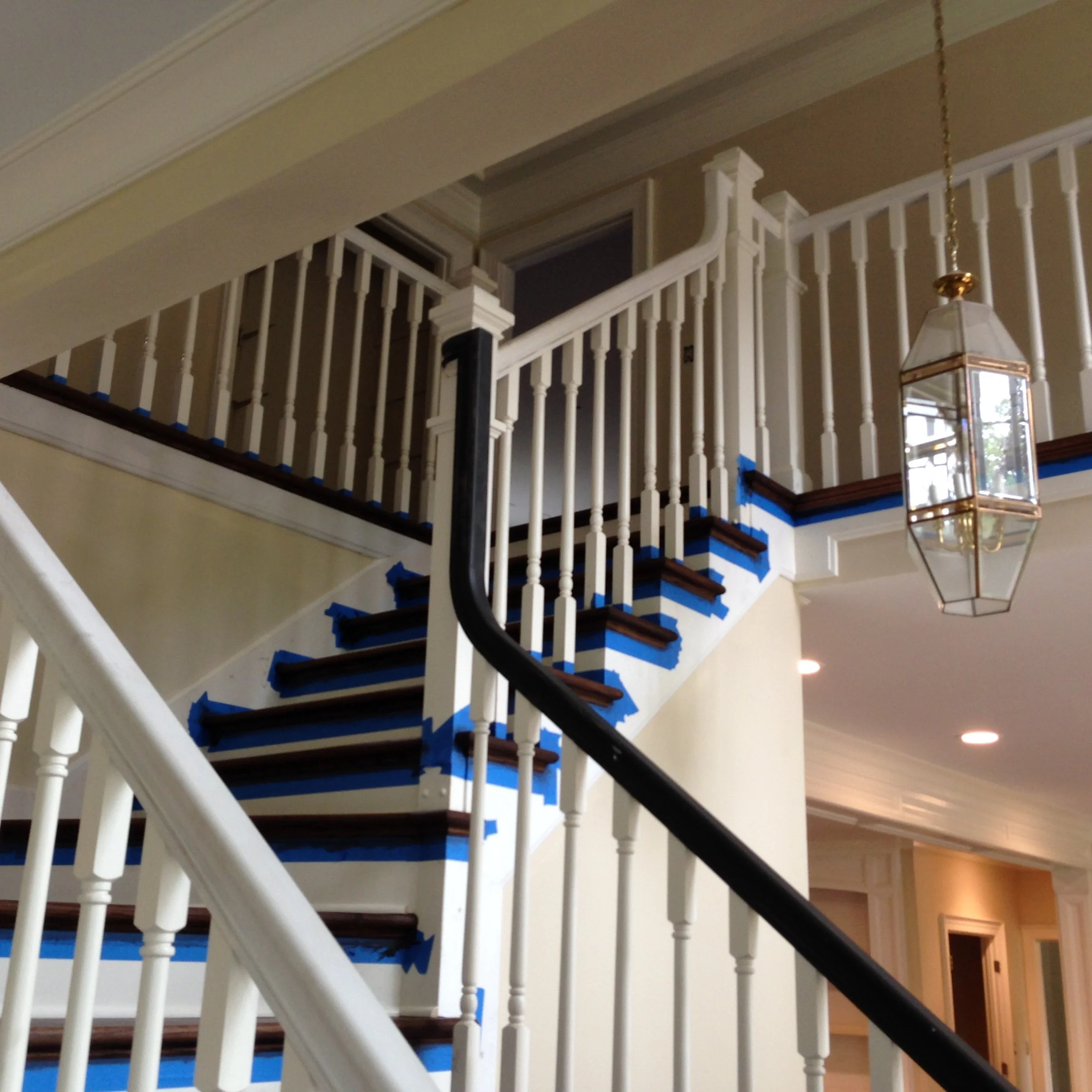 Interior view highlighting a custom staircase with dark wood treads and a tailored white railing system, featuring finely crafted spindles and handrail details that emphasize the architectural design and craftsmanship of the stairway.