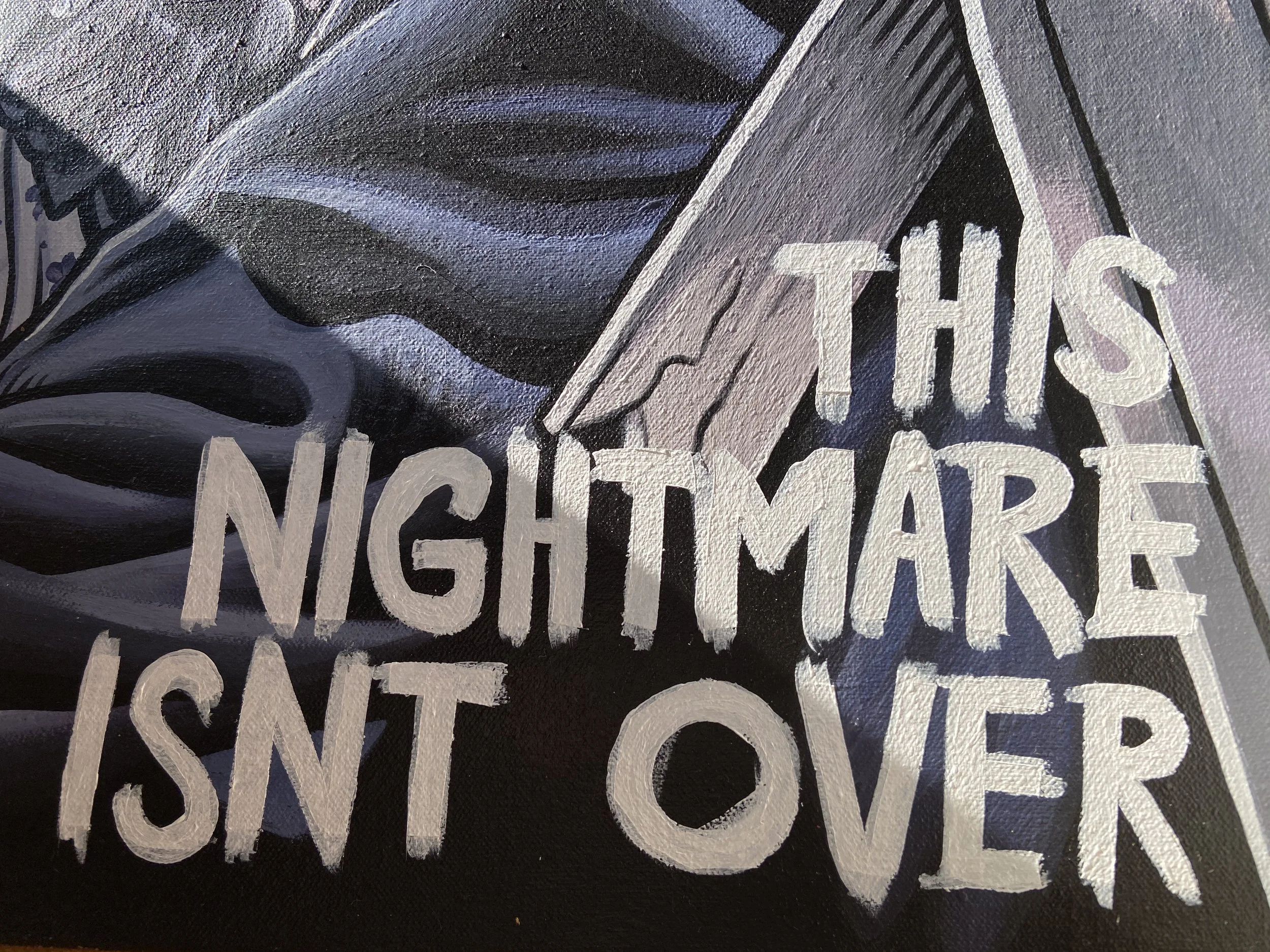 Close-up of a black surface with white painted text and a partial view of a knife with a black handle.