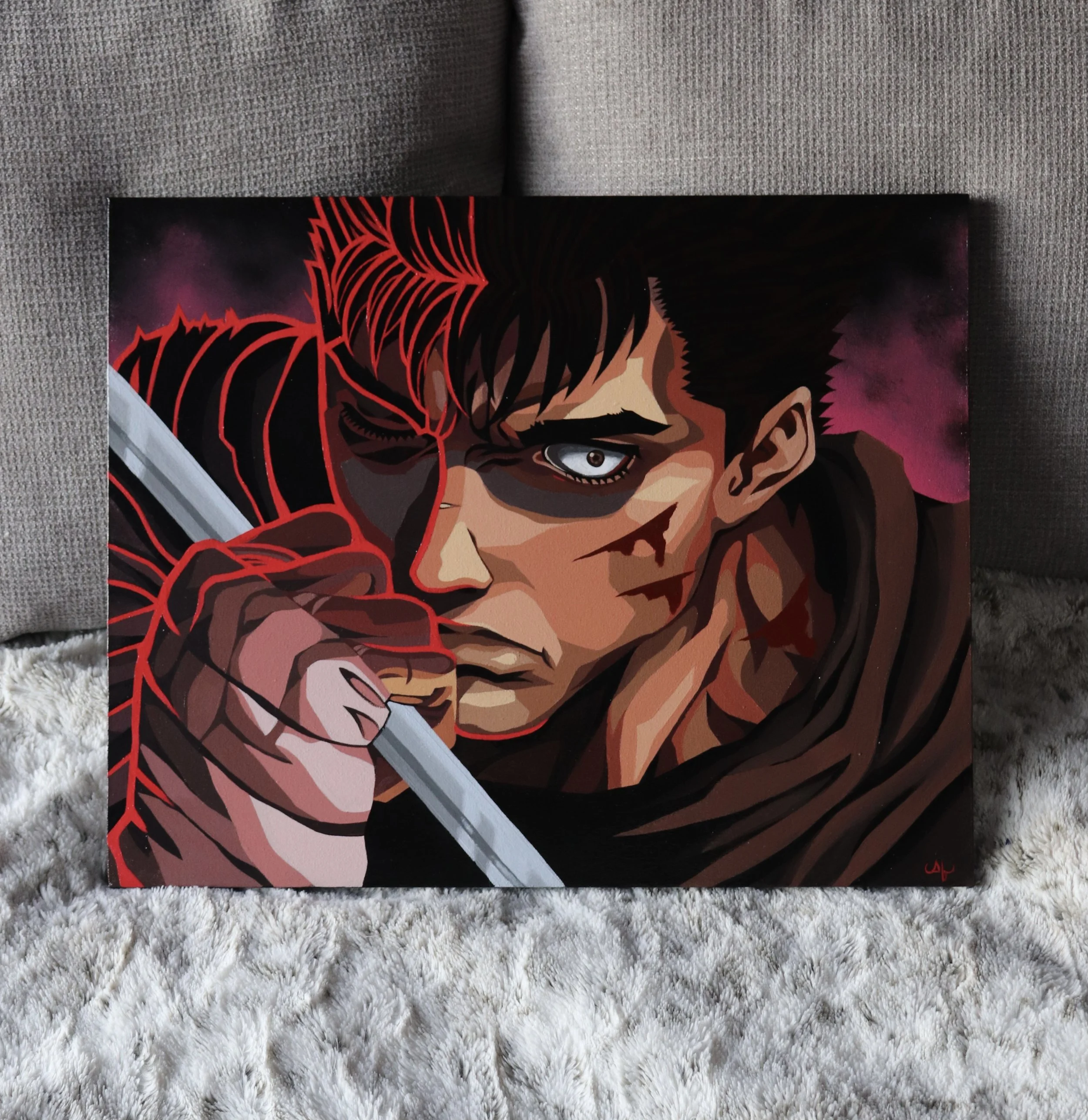 Close-up of a comic book cover featuring a man with a serious expression, one eye white and the other dark, with red and black stylized design elements around his face, placed on a gray textured surface.