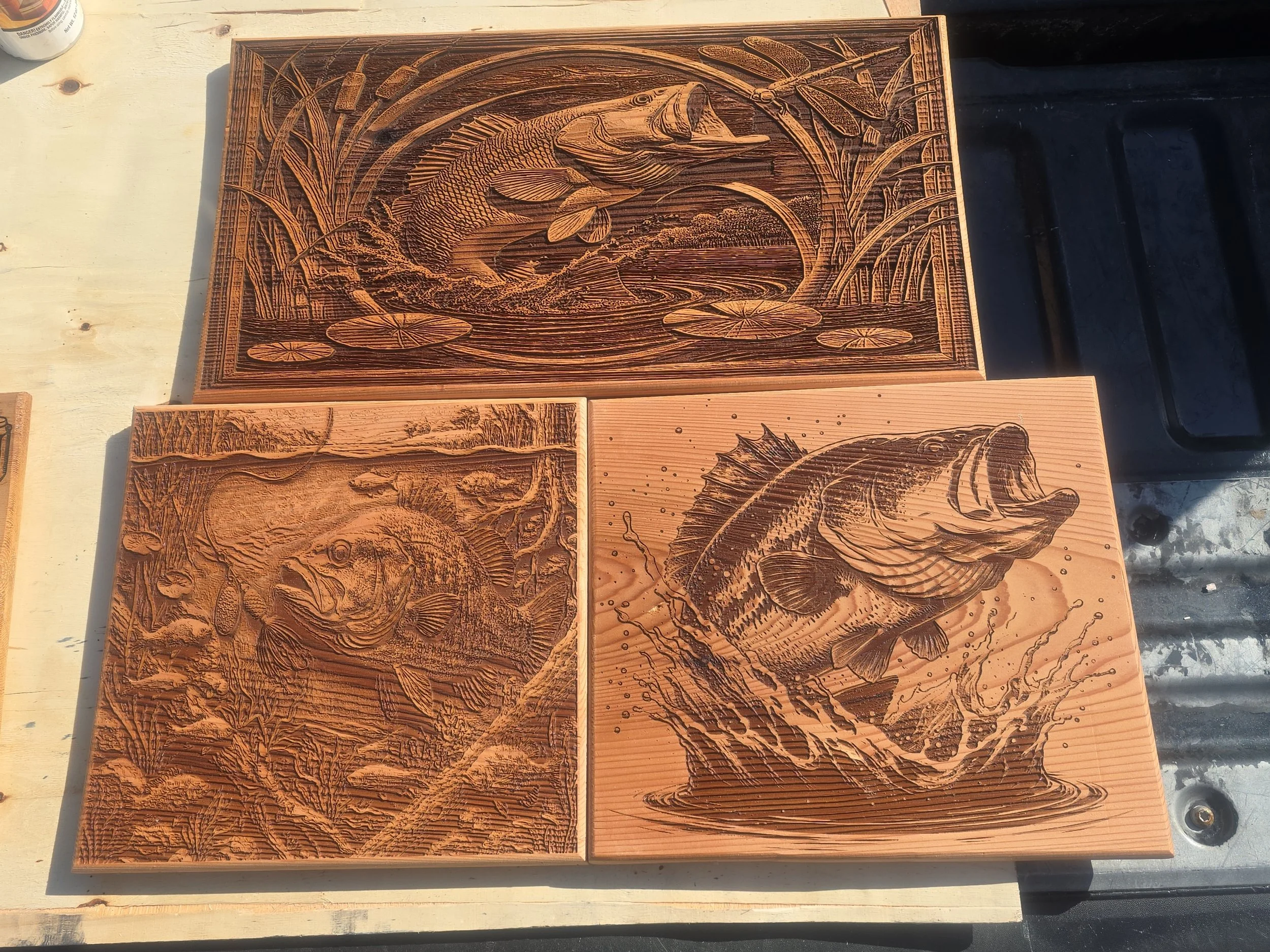 Wood carving artwork featuring a fish, aquatic plants, and water scene.