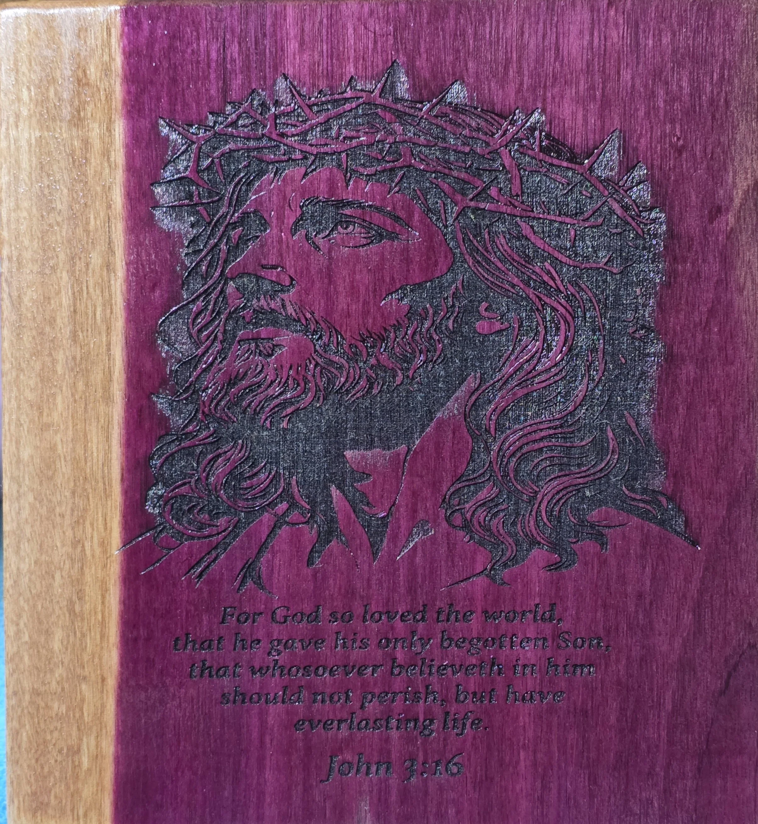 Black outline drawing of Jesus Christ with crown of thorns, on a pink background. Partially visible text at the bottom that reads: "For God so loved the world, that he gave his only begotten Son, that whosoever believeth in him should not perish, but