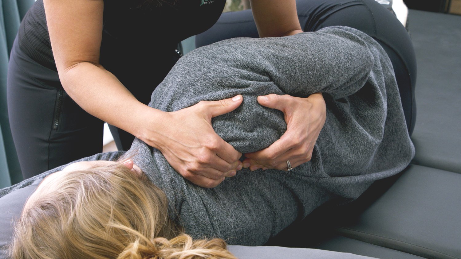 Kelsey provides hands-on care in a private setting to a client to manage pain due to scoliosis