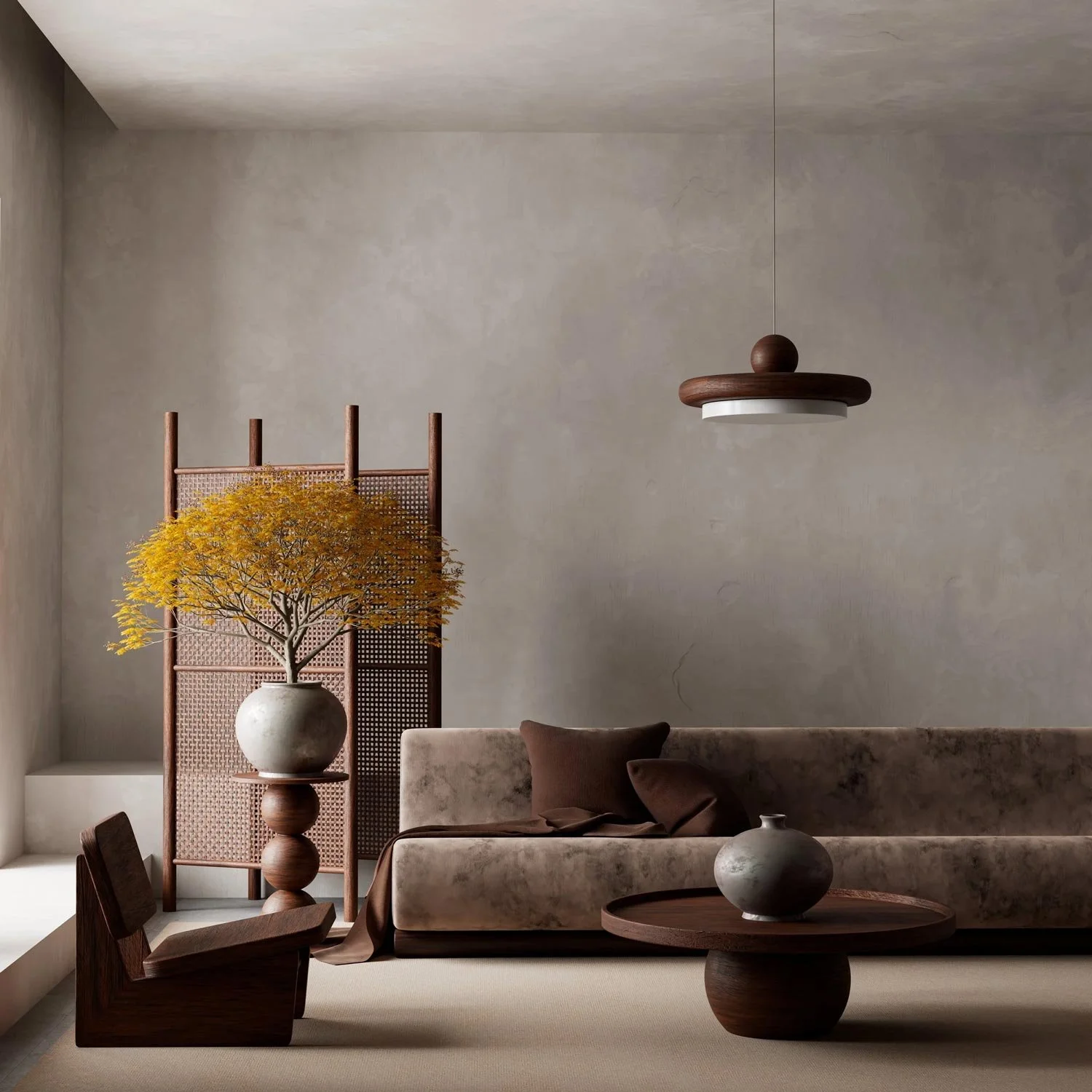 Minimalist living room with beige walls, a beige sofa with brown pillows, a wooden armchair, a round wooden coffee table with a gray vase, a potted yellow-orange tree in a large white vase, a wooden and woven room divider, and a modern hanging ceiling light.