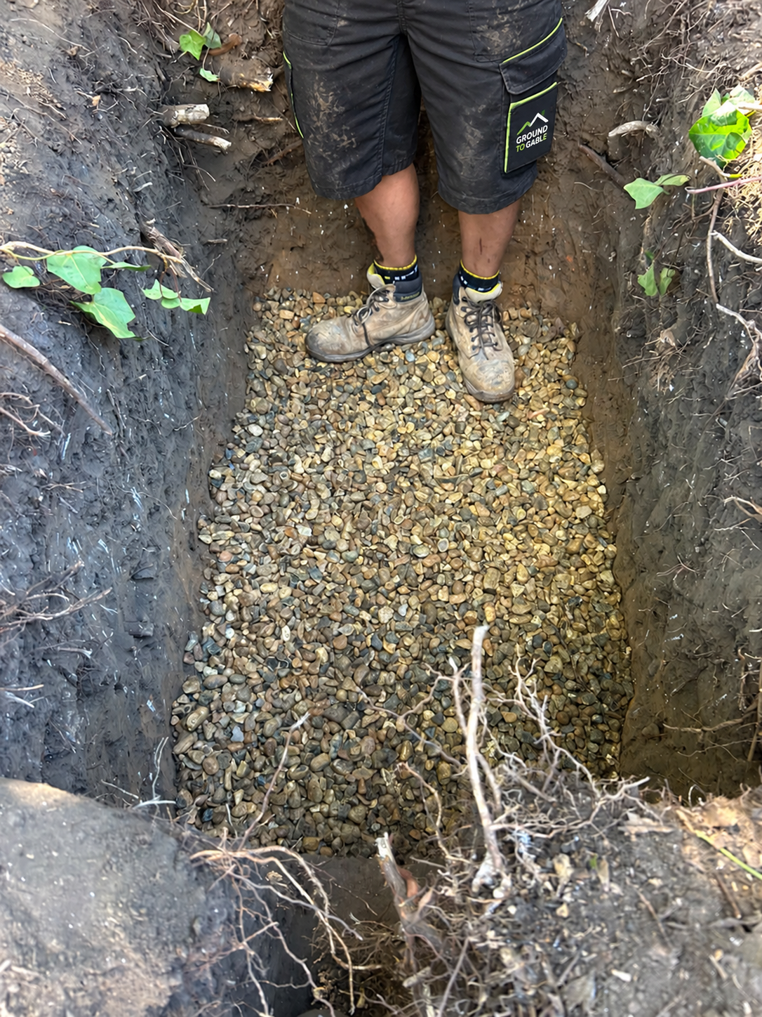 Stone at the base of an excavated pit during a Ground to Gable soakaway installation