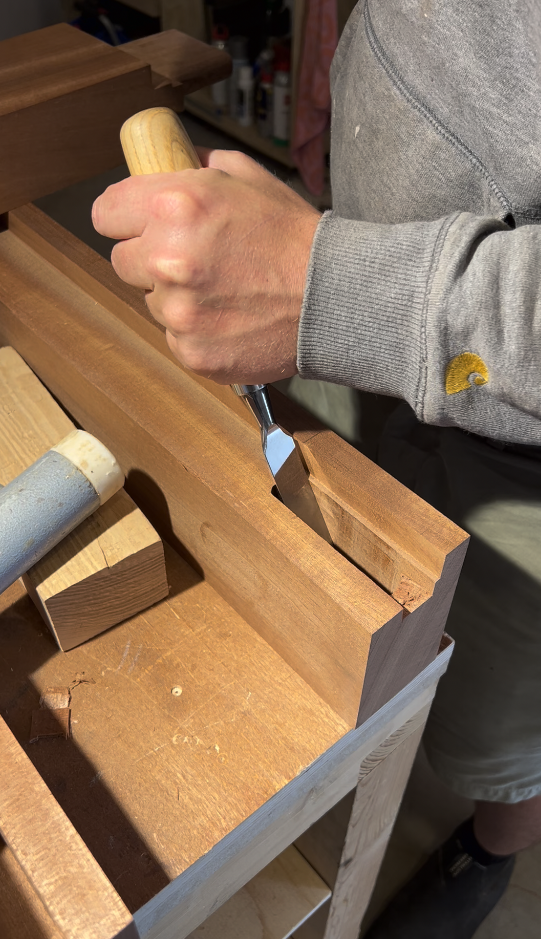 Luc Eggenhuizen de l'Atelier Set à Perros-Guirec utilise une gouge pour façonner un morceau de bois dans son atelier de menuiserie.