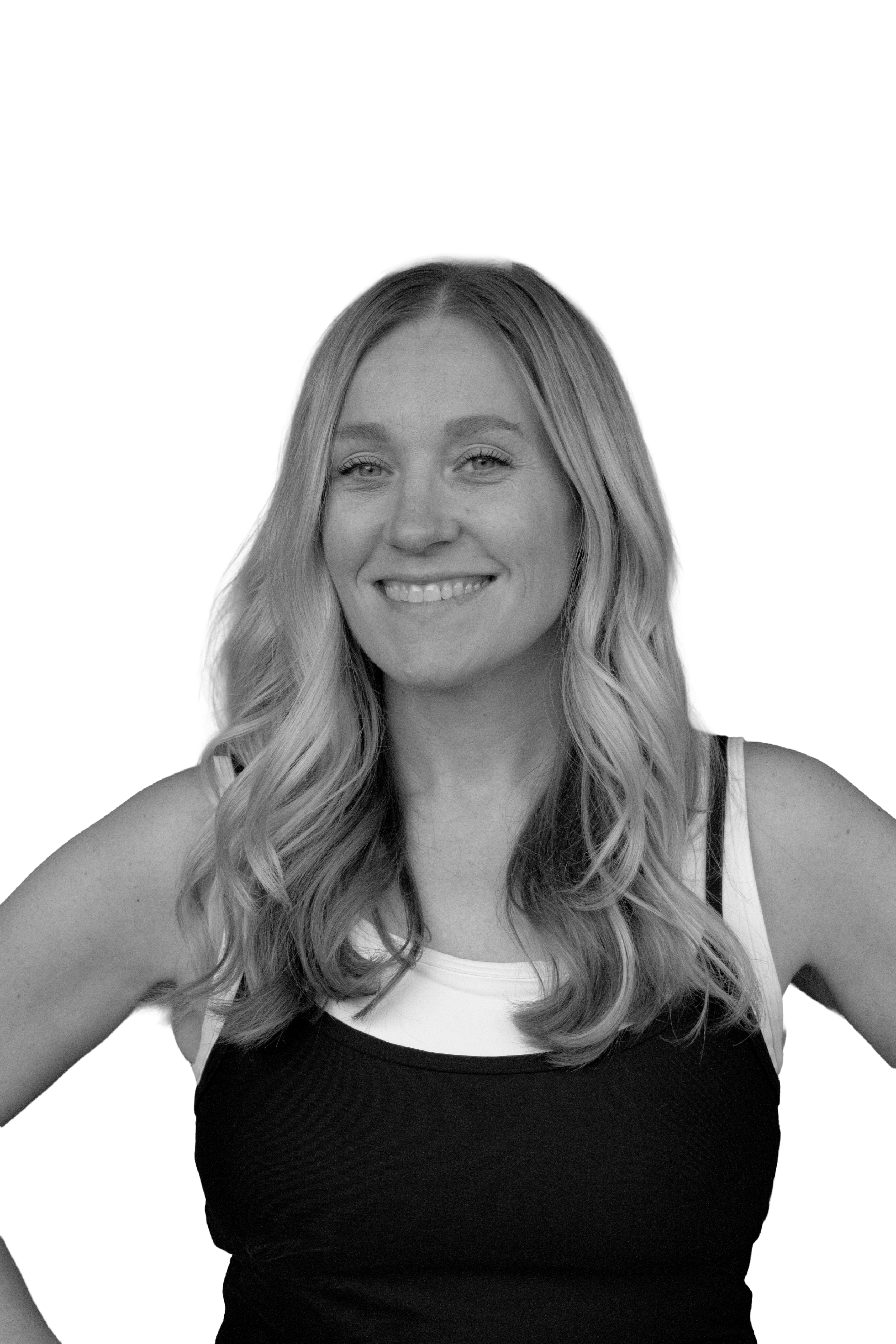 Black and white portrait of a young woman with long wavy hair, smiling, wearing a tank top with a color block design.