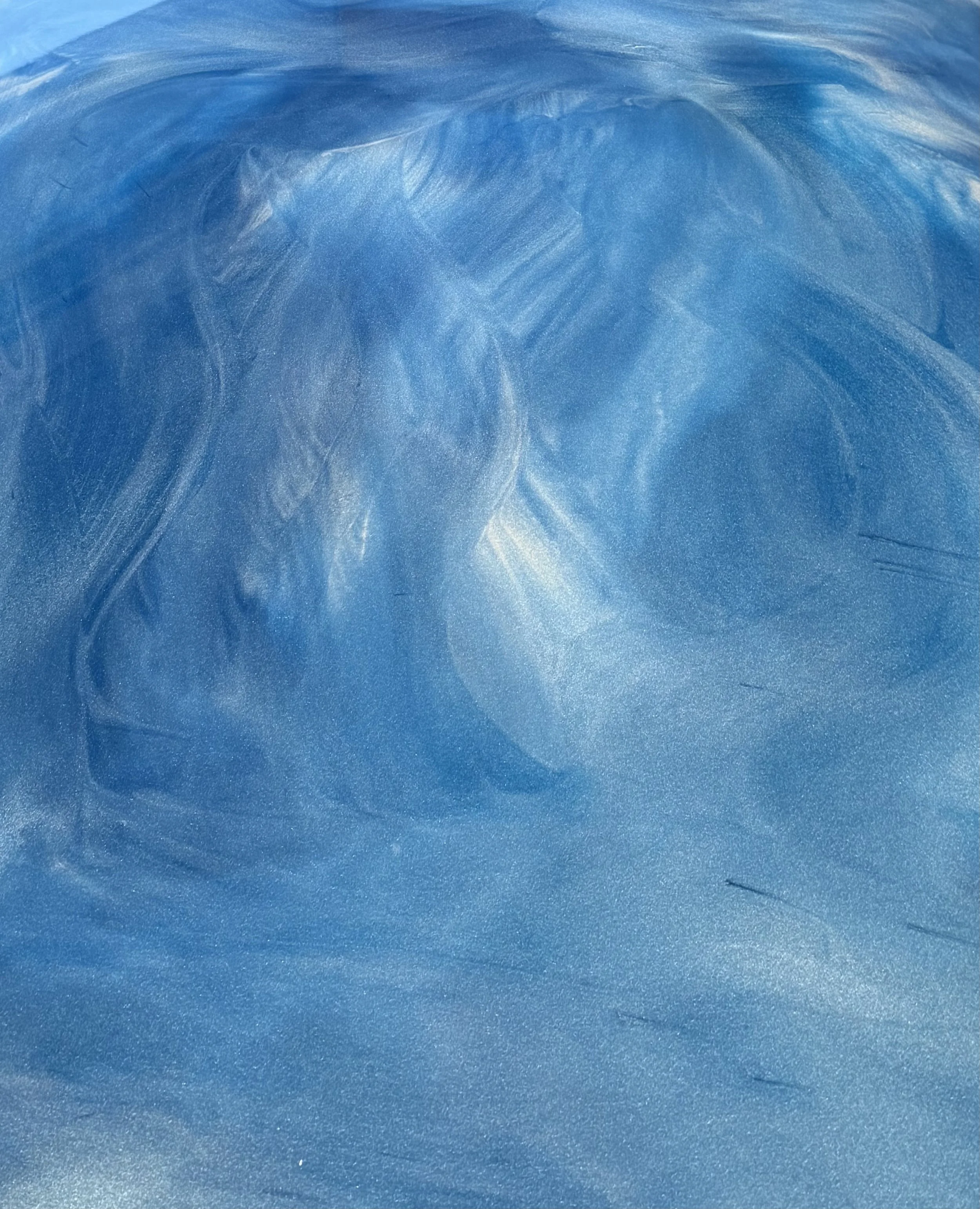 Close-up of a Metallic Epoxy System with swirling blue and white pattern, resembling marbled.