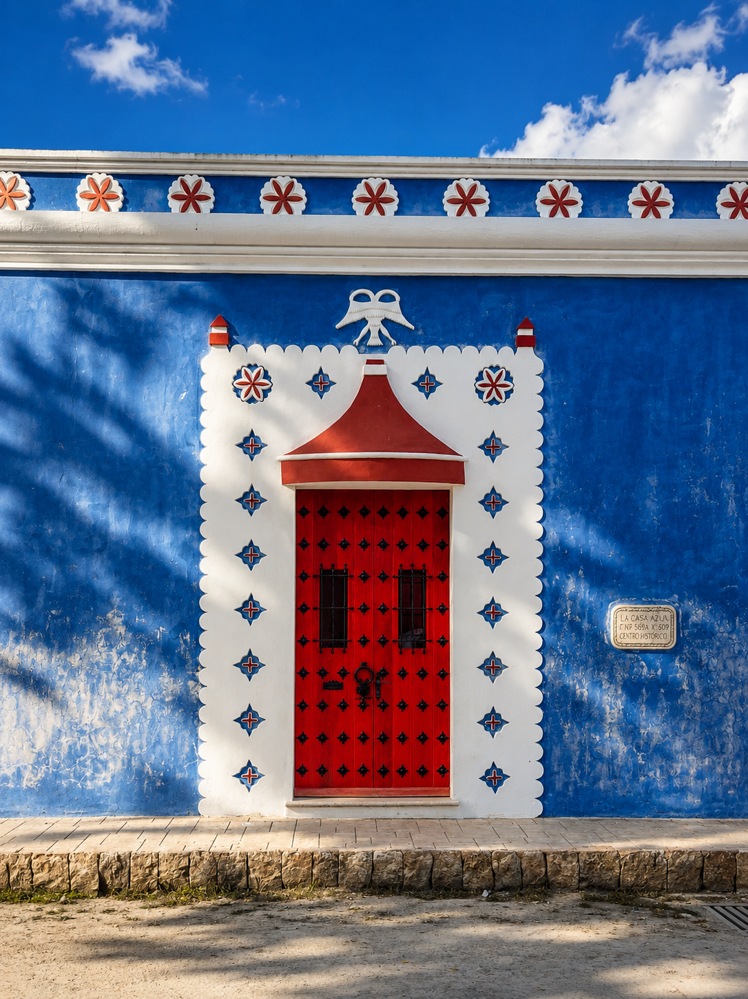 Colorful colonial building in Yucatán featuring a vibrant blue façade and traditional red doorway, showcasing the region’s distinctive architecture and cultural heritage.