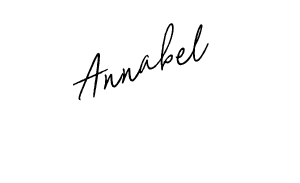 A close-up of a metal lota with a black handle, placed on a black surface.
