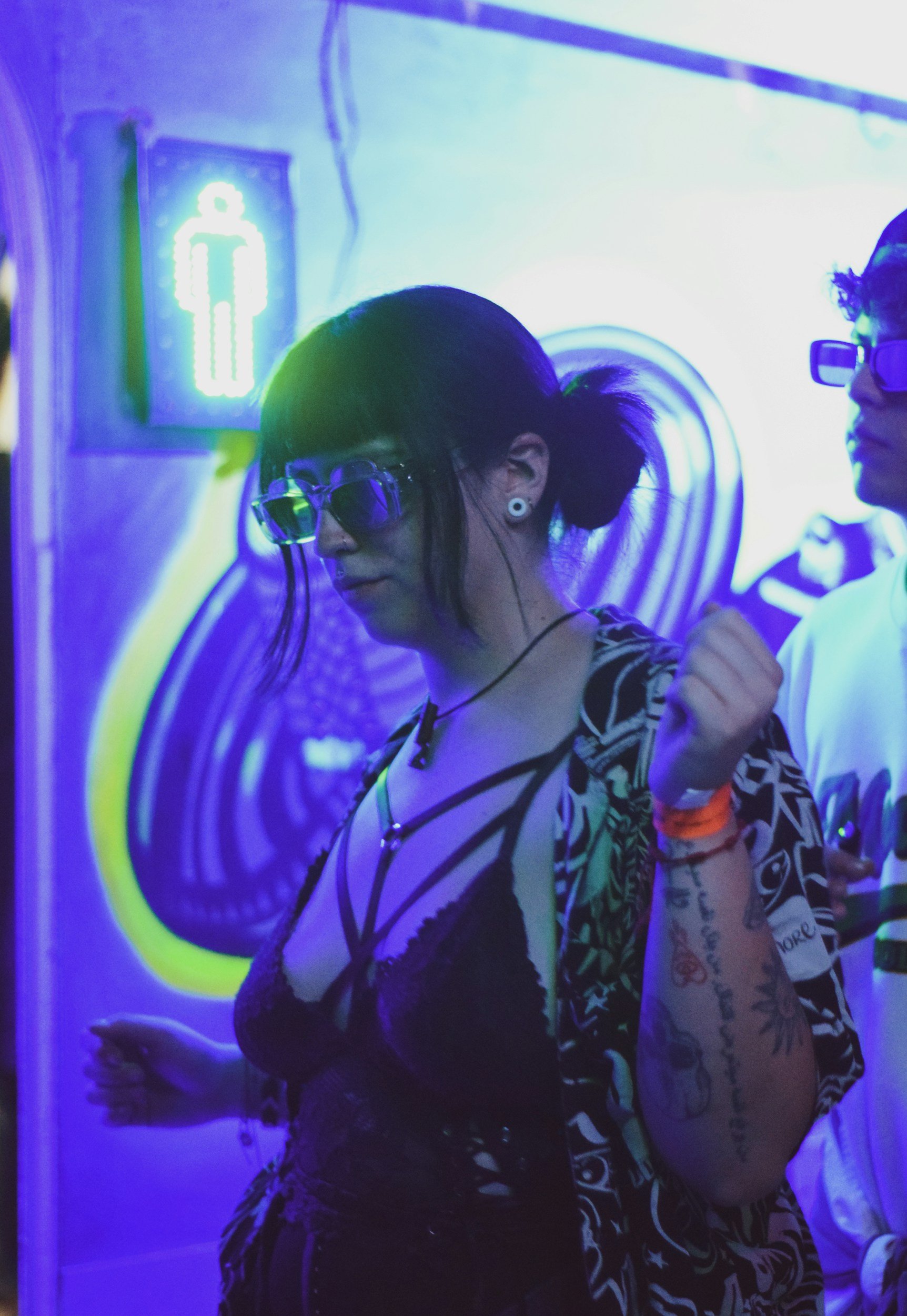 Content creators interacting in an atmospheric neon-lit event space, highlighting community building and authentic engagement in nerdy pop culture spaces.