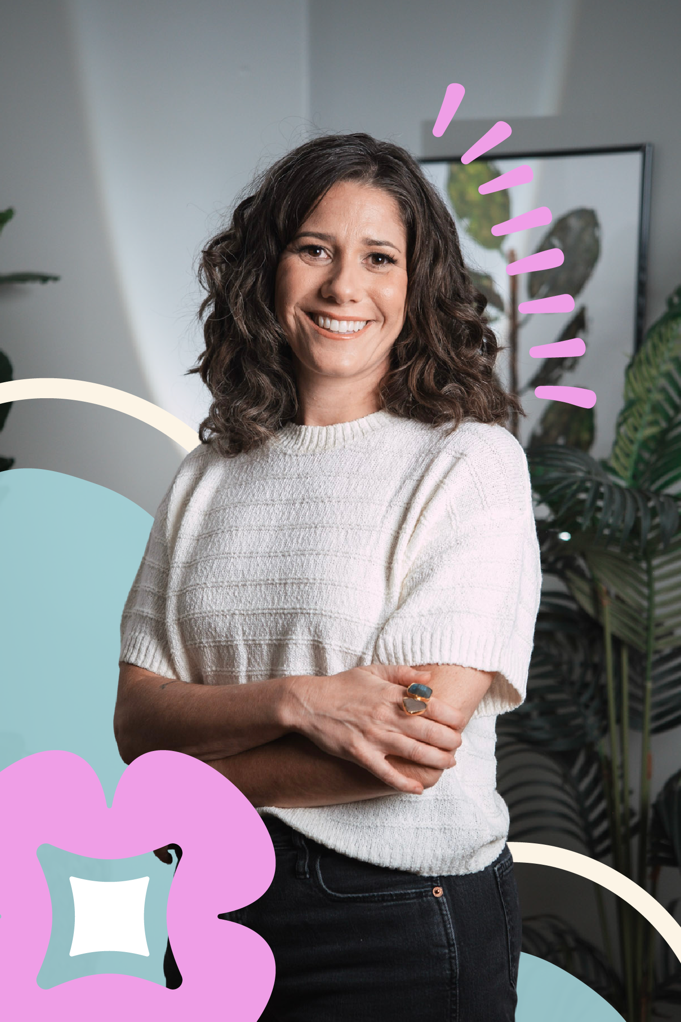 A woman with dark wavy hair smiling, wearing a white textured short-sleeve sweater and a ring, standing in a room with potted plants and a television in the background, decorated with colorful graphic elements.