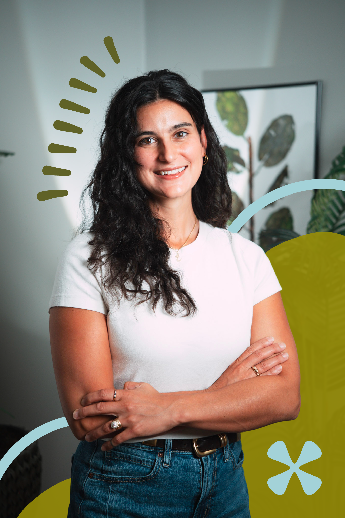 A woman with dark hair wearing a white shirt and blue jeans is smiling with her arms crossed, standing in front of a background with plants and colorful graphic elements.