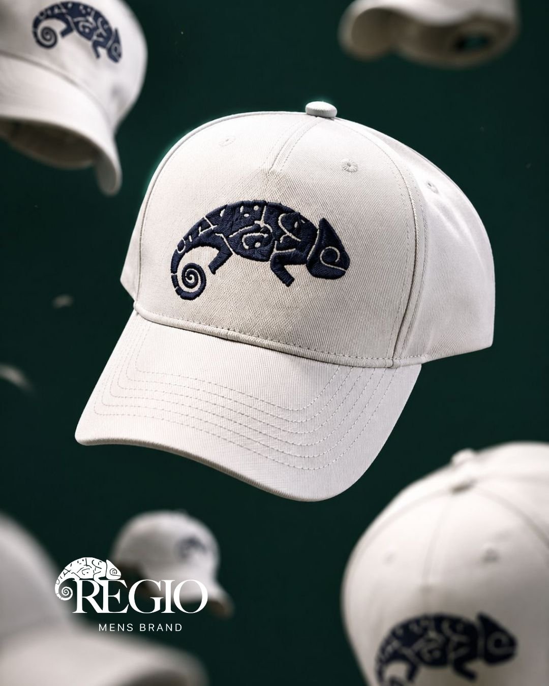 Chapéu branco com logotipo de lagarto azul e detalhes em relevo, suspenso no ar, com outros chapéus semelhantes ao fundo. Logo da marca Regio Masculino visível na parte inferior esquerda.