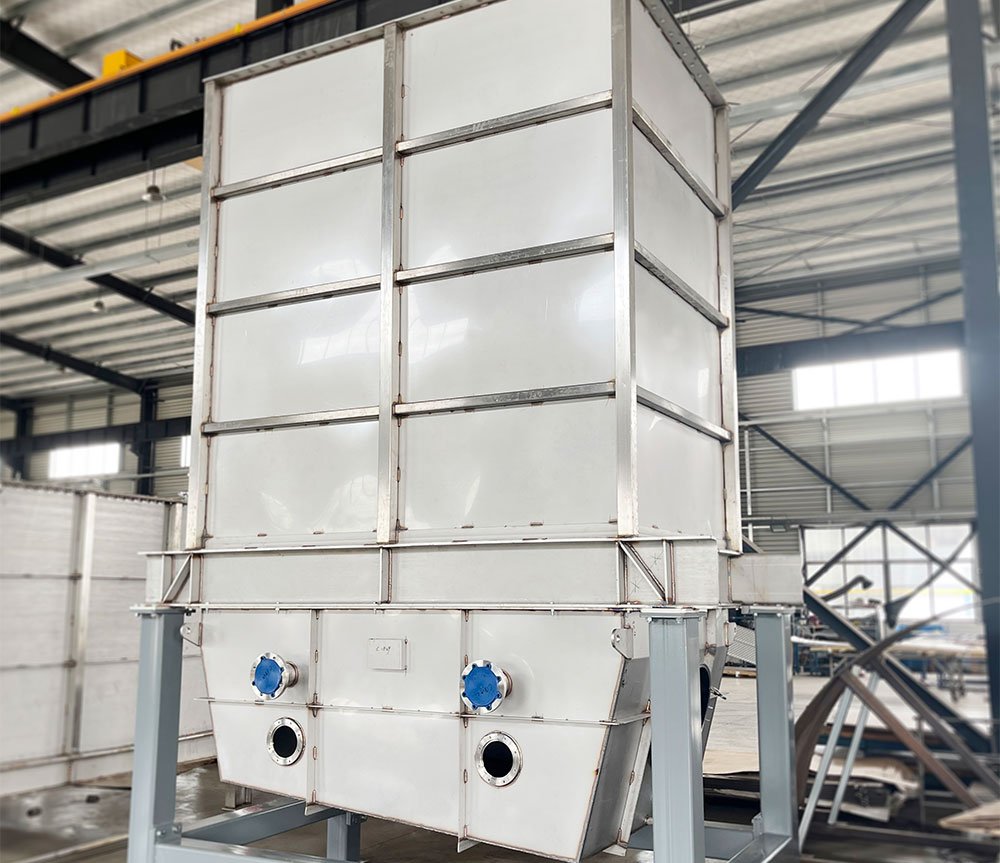 Industrial industrial equipment with large white modules, two blue caps on the front, and circular openings, inside a warehouse