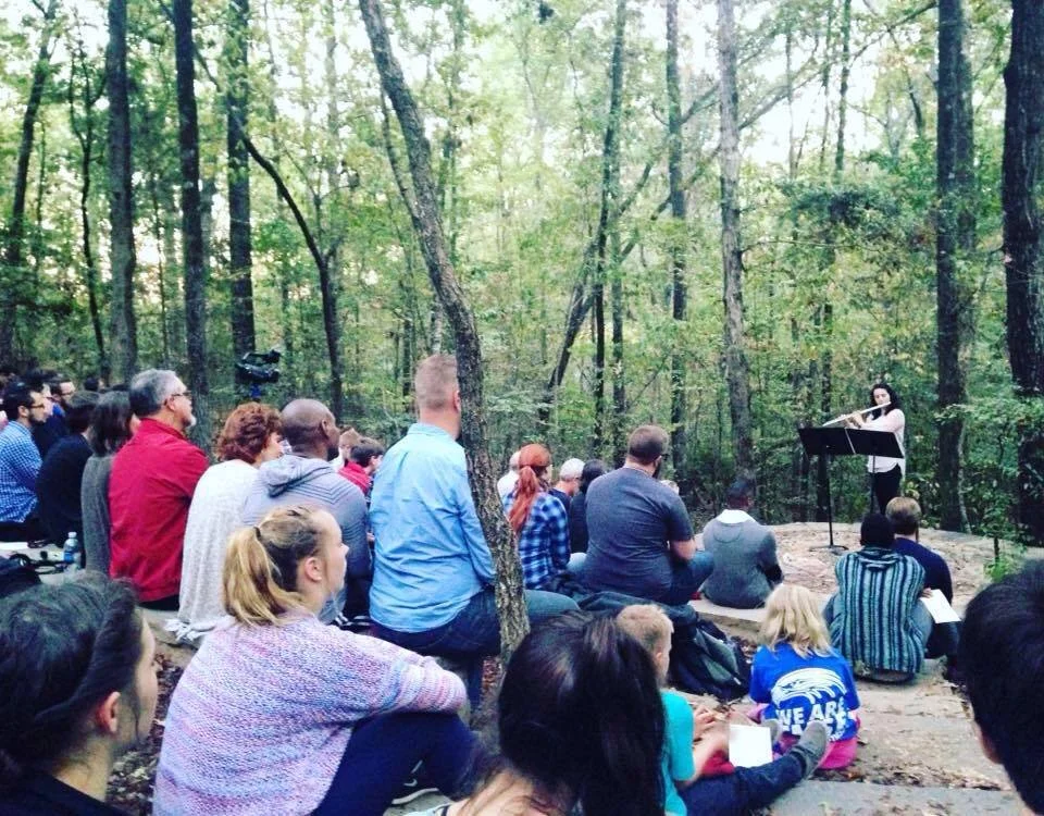 An image of Michelle Scroggie as a flute performer in an outdoor space.