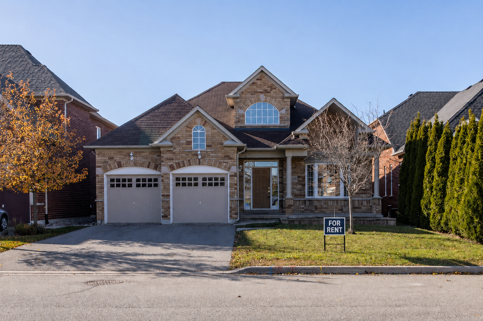 A two-story brick house with a front porch, two-car garage, and a "For Rent" sign in the front yard, located on a suburban street with neighboring houses on both sides.