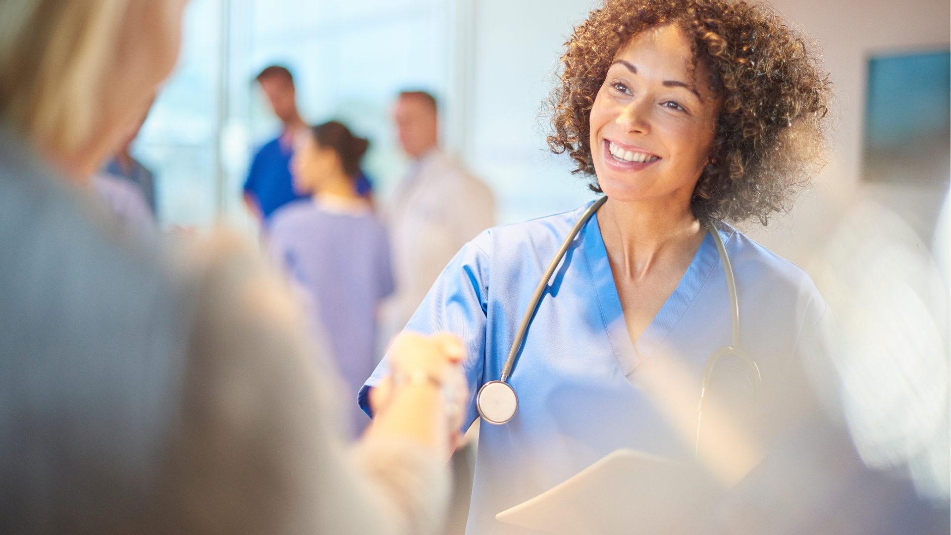 bi-racial female nurse or doctor shaking hands with someone