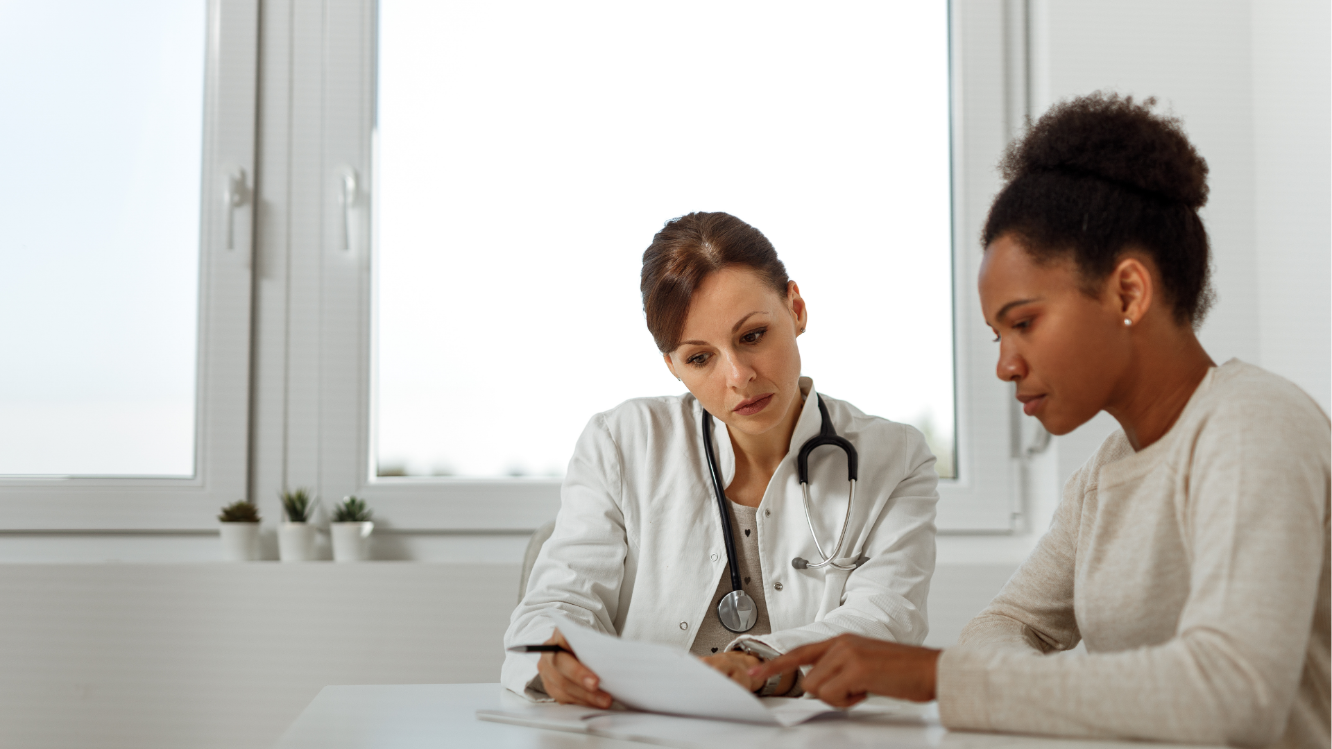 Female doctor and female patient looking at a medical chart