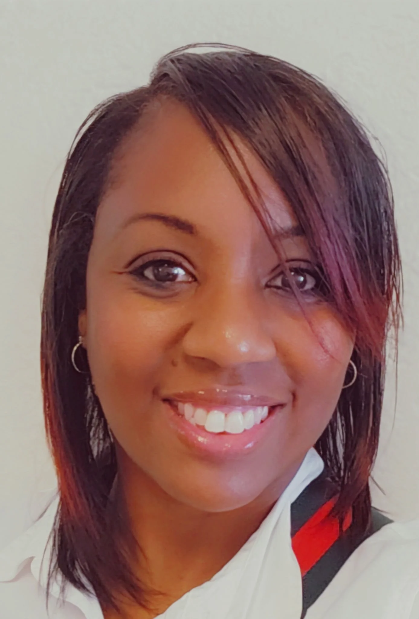 Headshot of smiling female tutor with long braids wearing a lanyard.