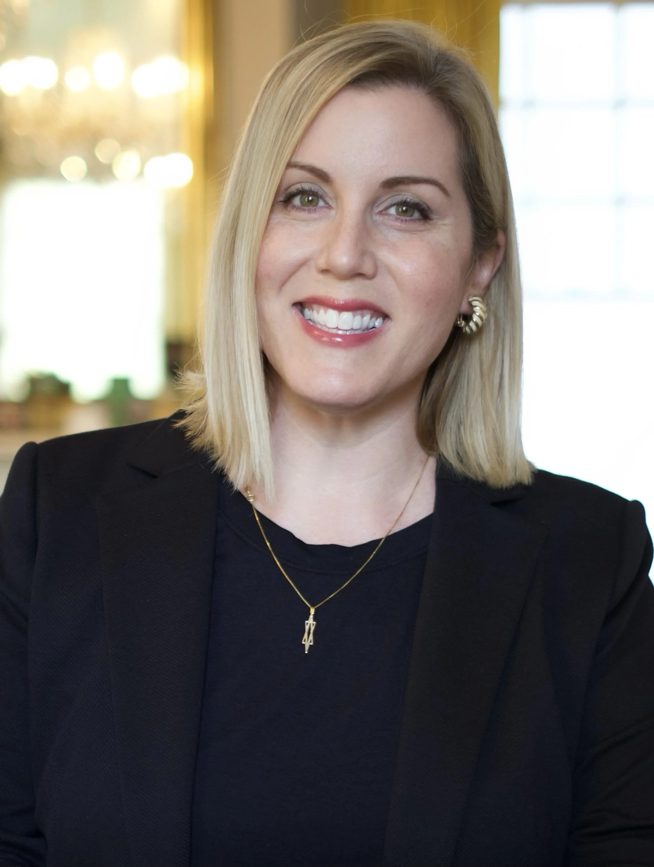 Headshot of smiling female tutor with short blonde hair wearing a lanyard.