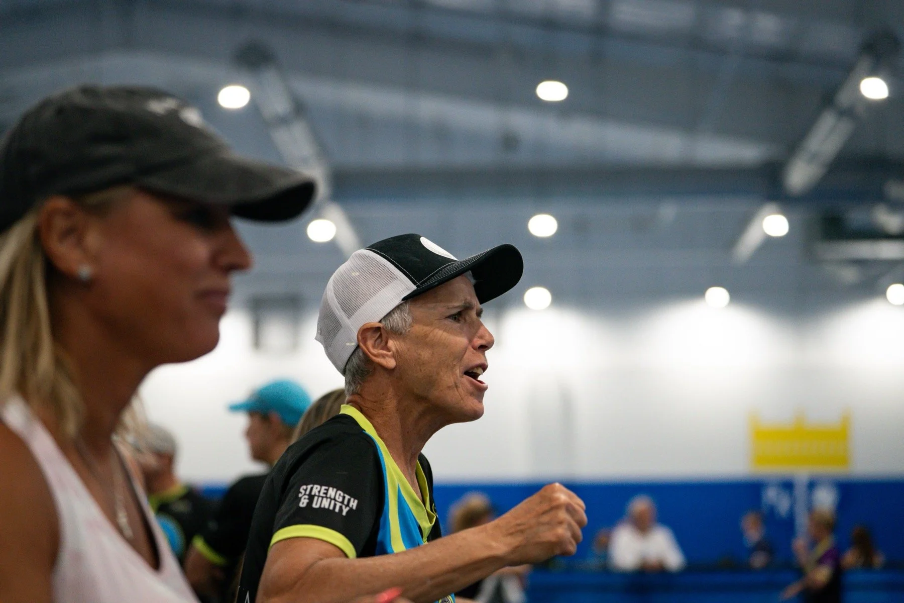 A group of people cheering at a pickleball match