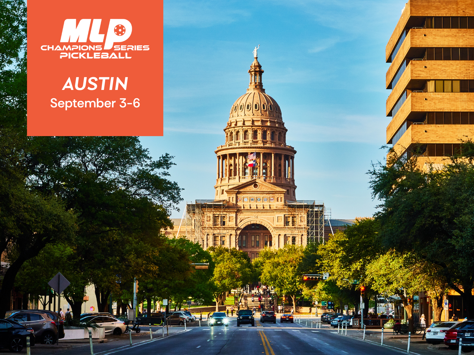 The Texas State Capitol building in Austin, Texas, viewed from a city street with cars and trees in the foreground, and a clear blue sky overhead.