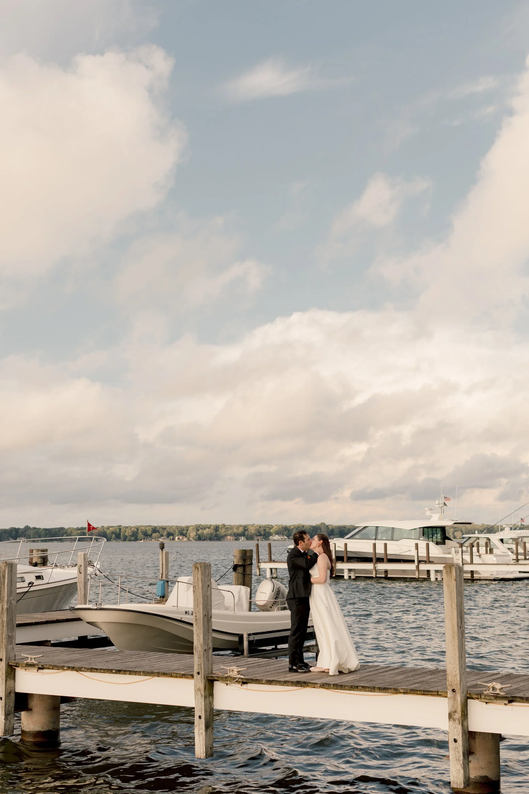 Bride and groom stealing a kiss on the dock at their Michigan wedding