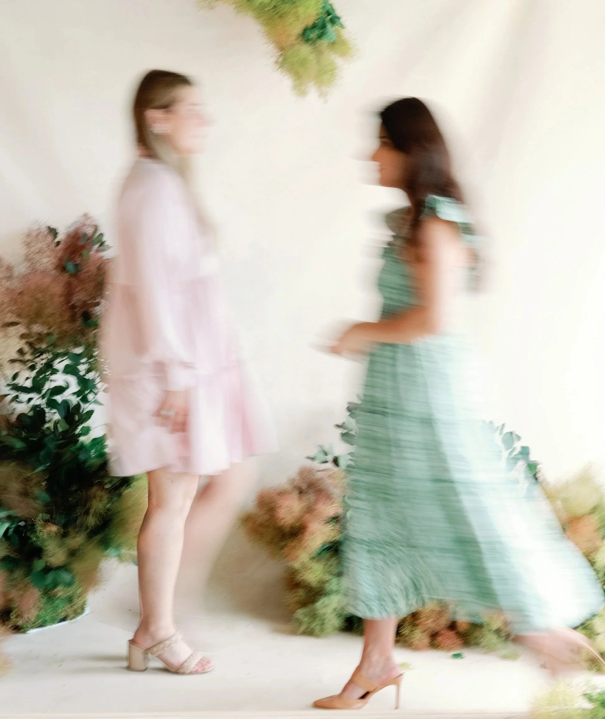 two wedding planners walking through floral installation