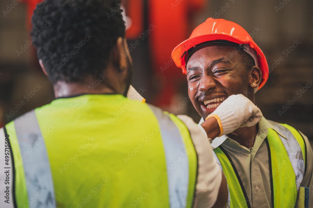 Two construction workers, one smiling, in safety gear, on a construction site.