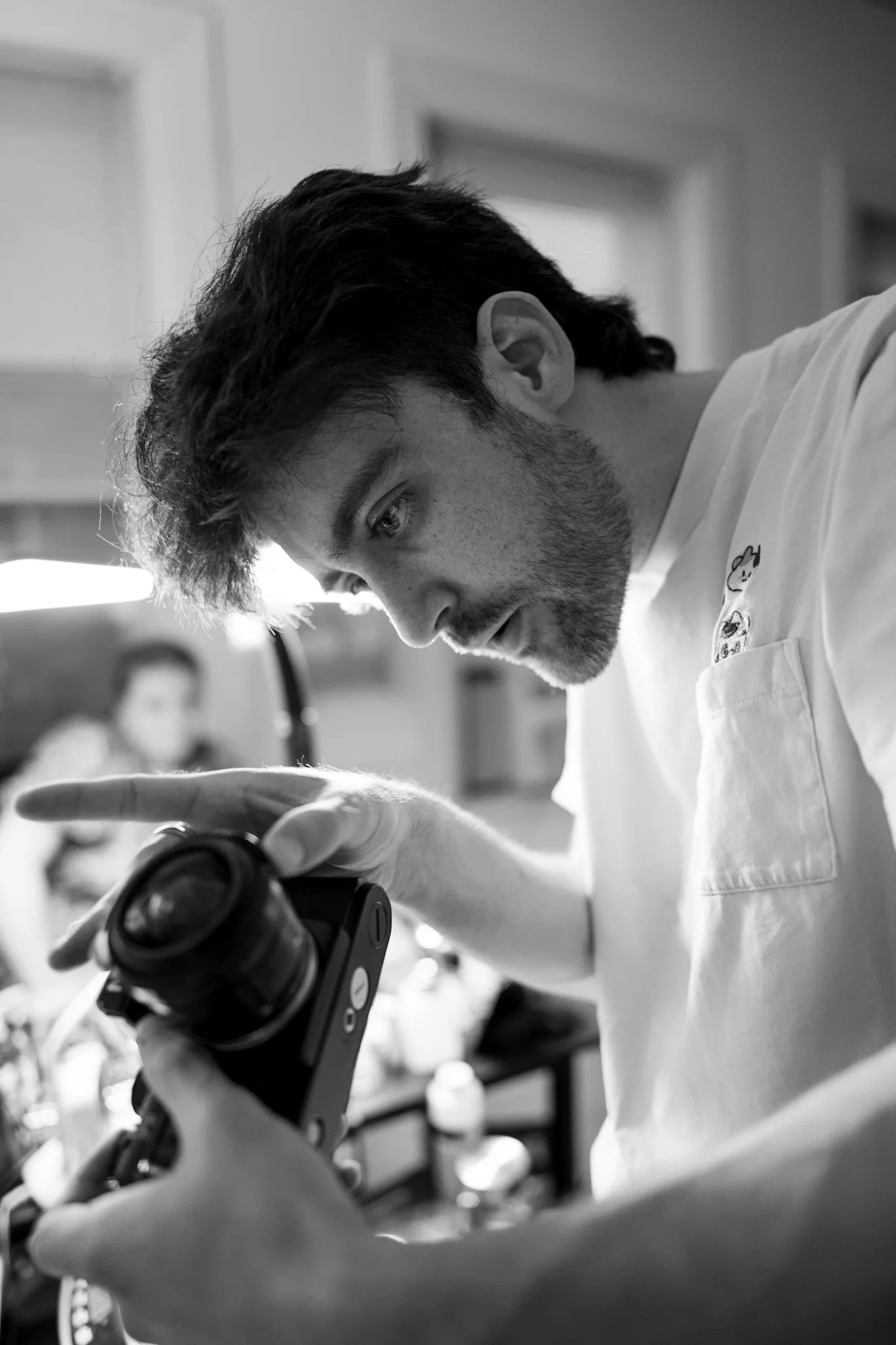 A male scientist or researcher examining a sample through a microscope in a laboratory setting.