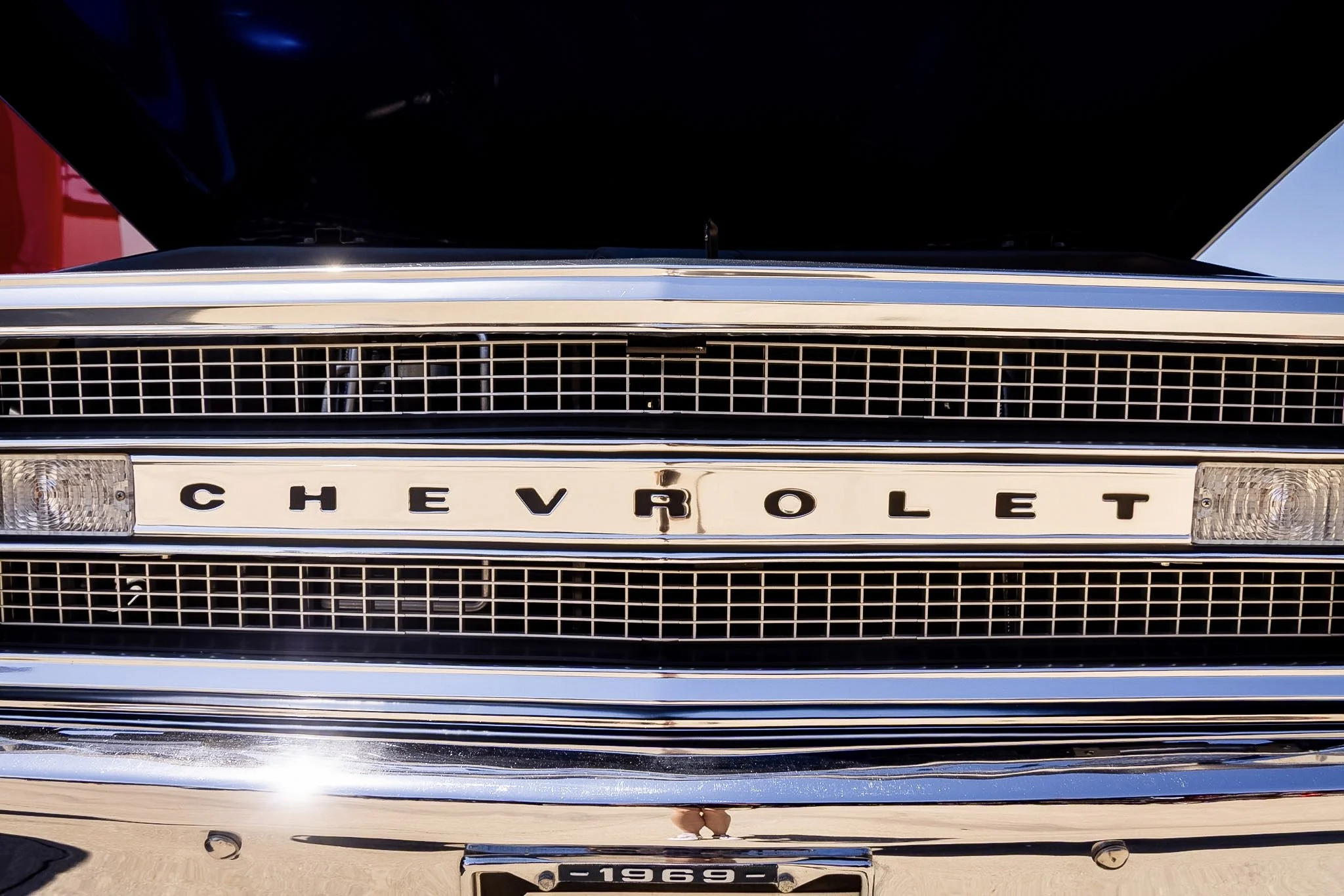 Front view of a vintage Chevrolet car showing the grille, hood, and part of the bumper with a Chevrolet emblem and a license plate reading '1969'.