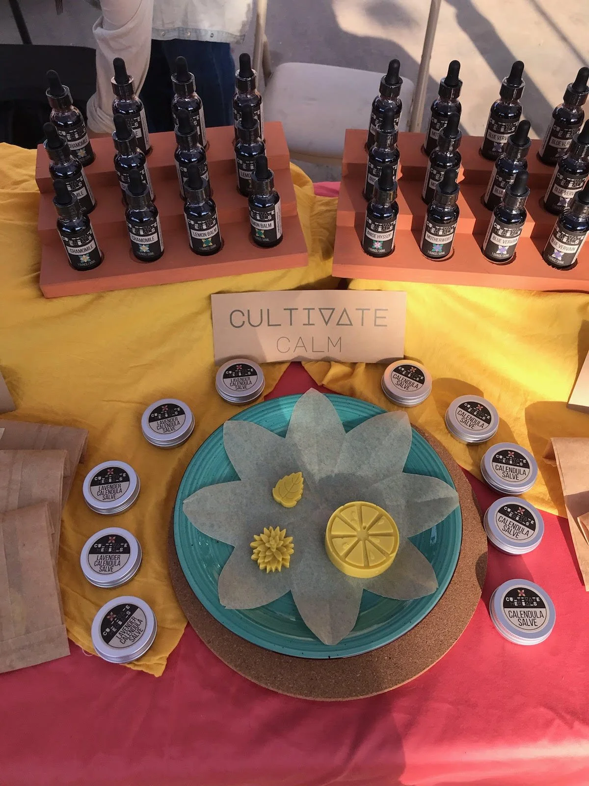 A display of nervine tinctures, calendula salves, and herbal lotion bars