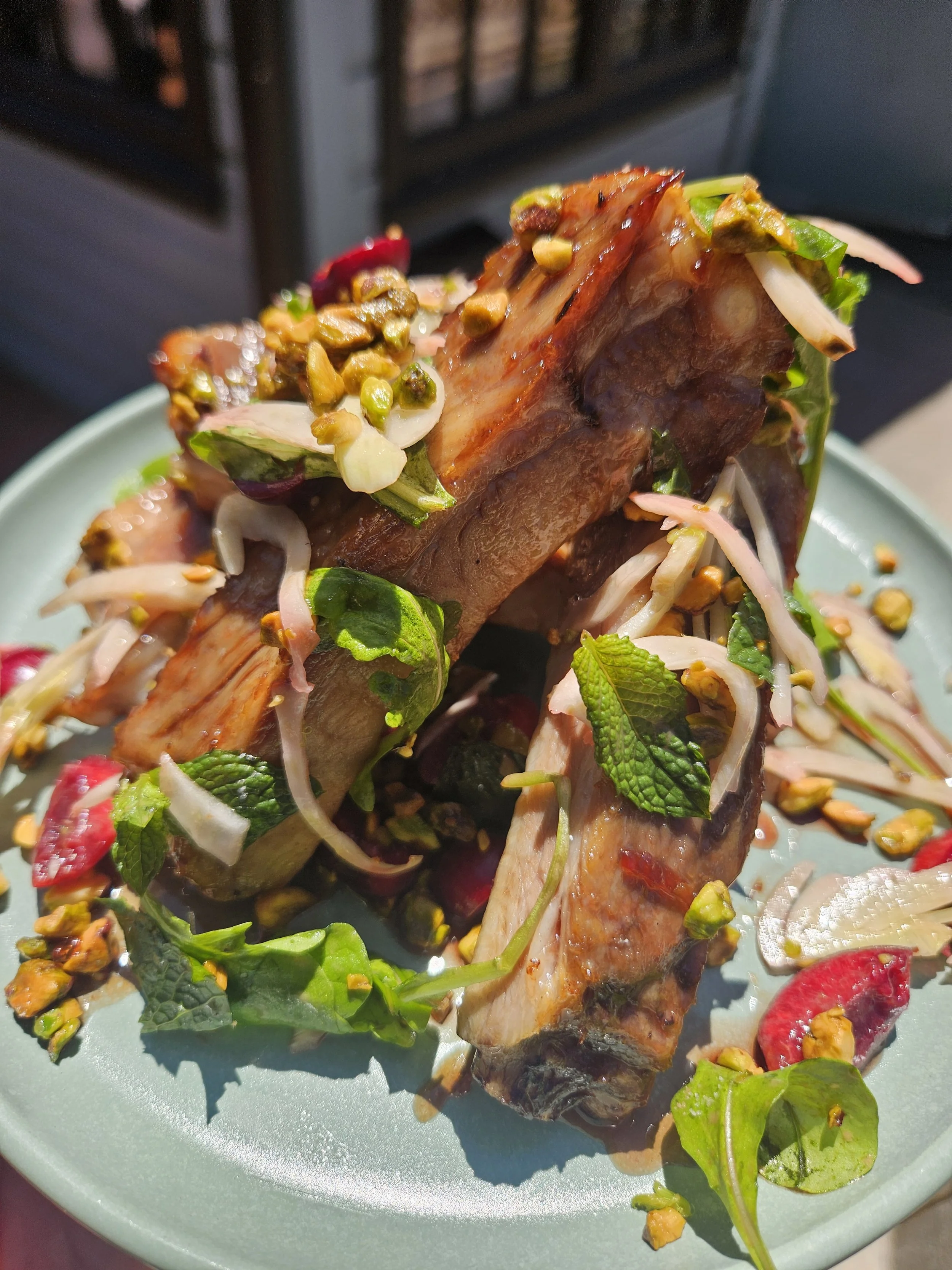 Grilled spare ribs with cherry agrodolce, cherries, mint, and pistachio