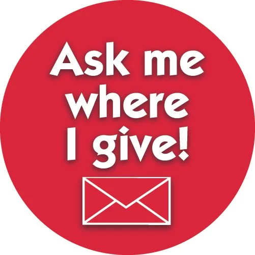 Red circular sign with white text stating 'Ask me where I give!' and a white envelope icon.
