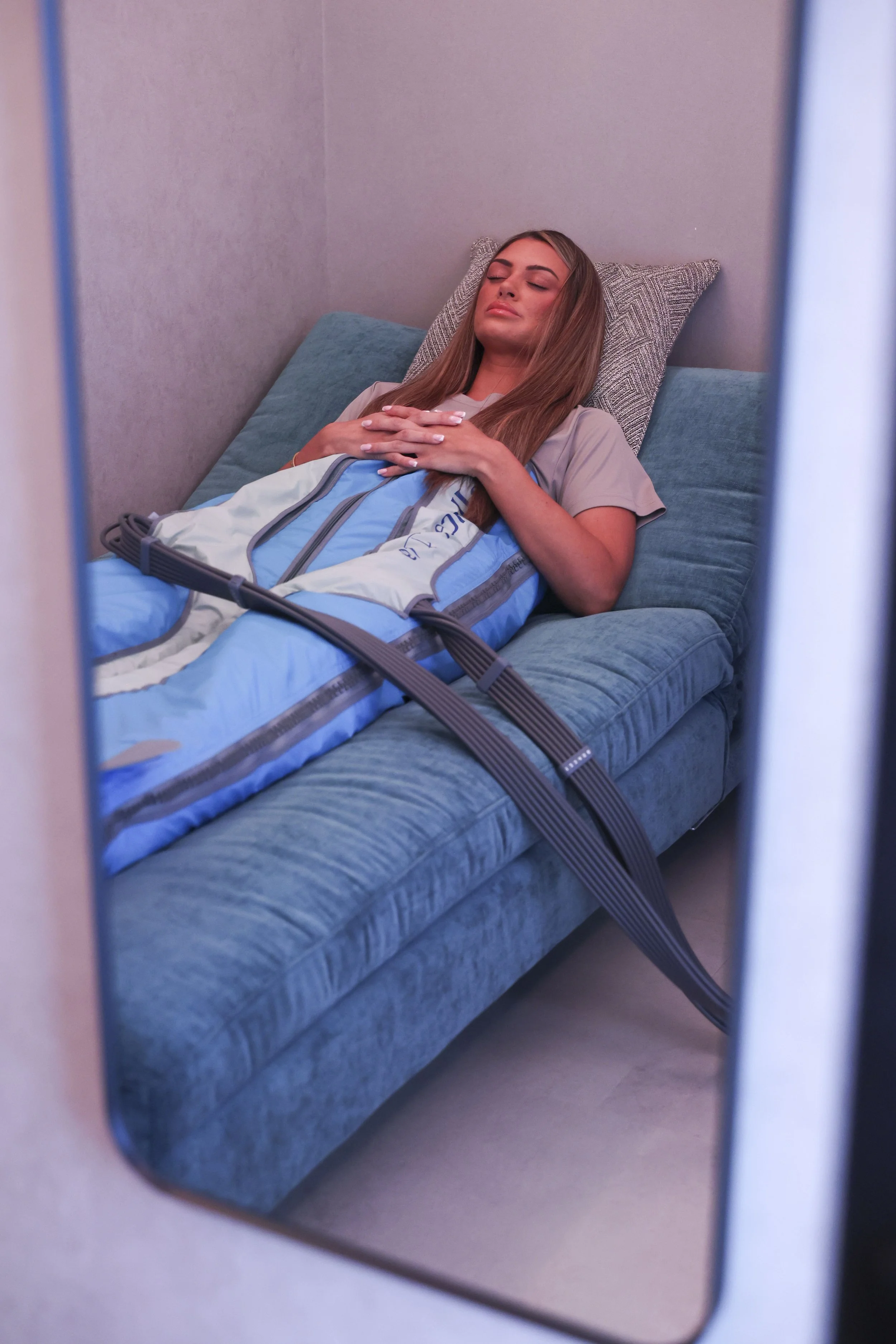 Reflection of A client is relaxing and enjoying the benefits of The Cold Room's Body Ballancer for lymphatic drainage.