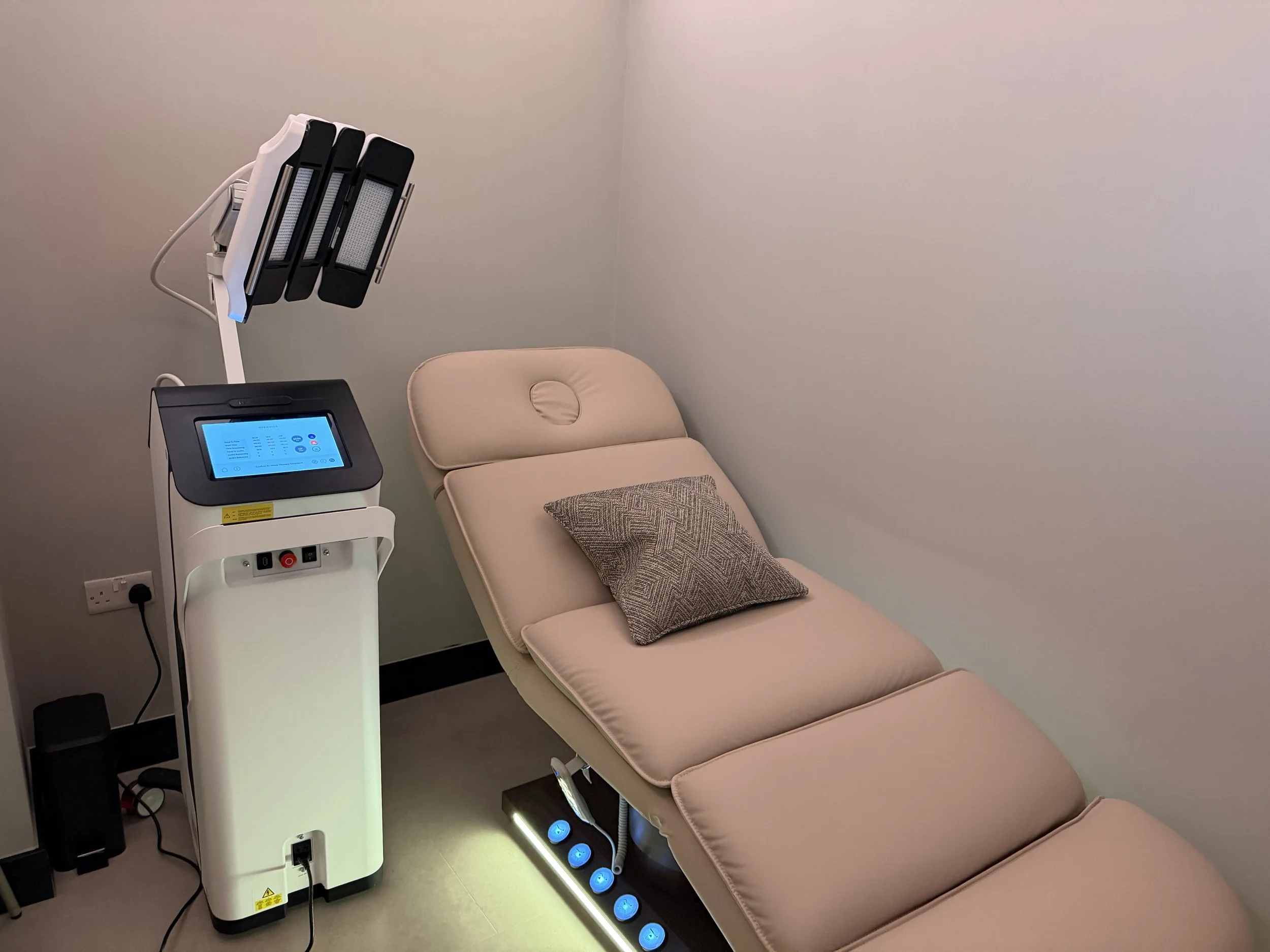 The Cold Room's medical grade Dermalux LED Light Therapy unit alongside the adjustable treatment bed in a private treatment room.