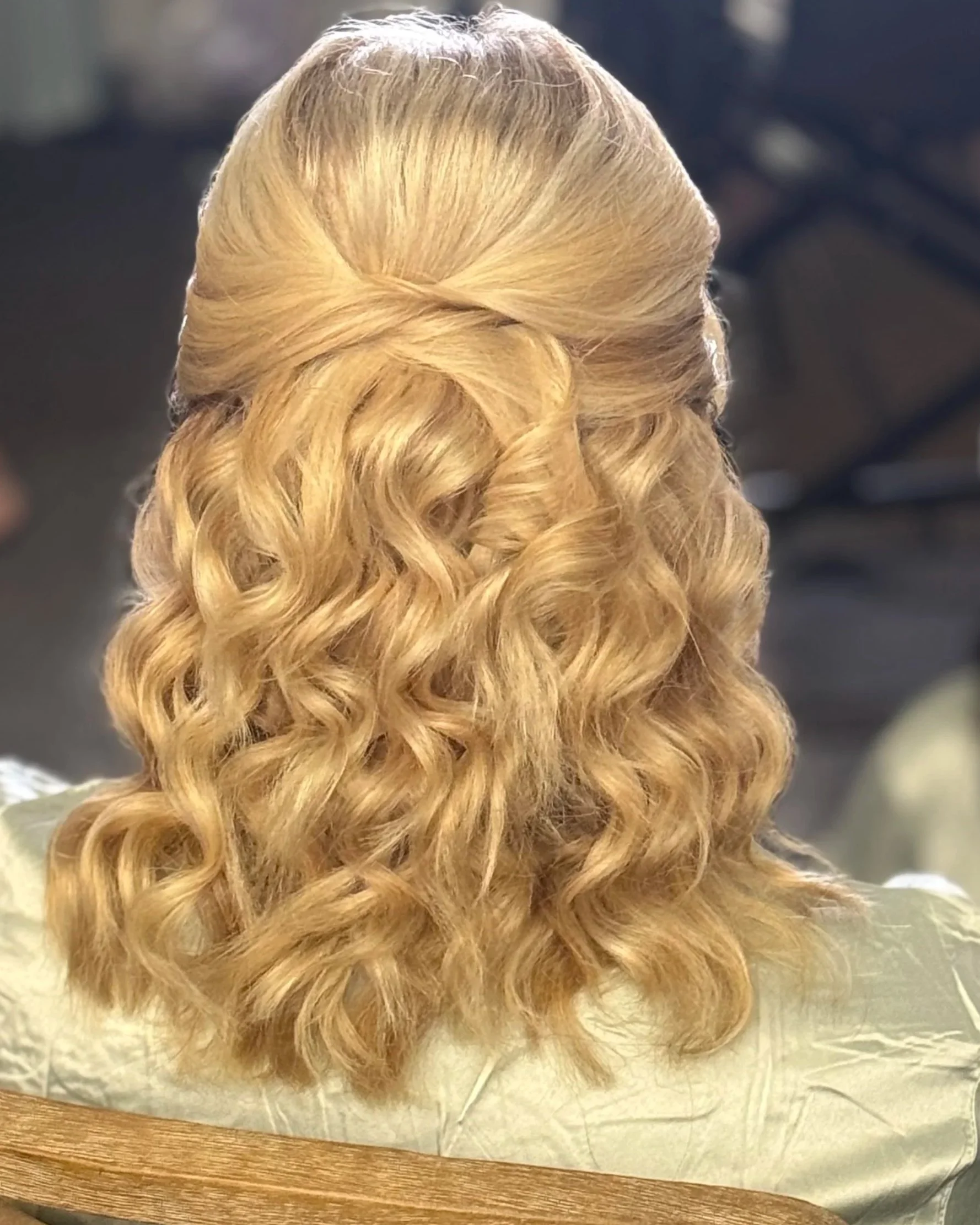 Blonde hair styled in tight curls with a twisted section at the top, resting on a white hair net.