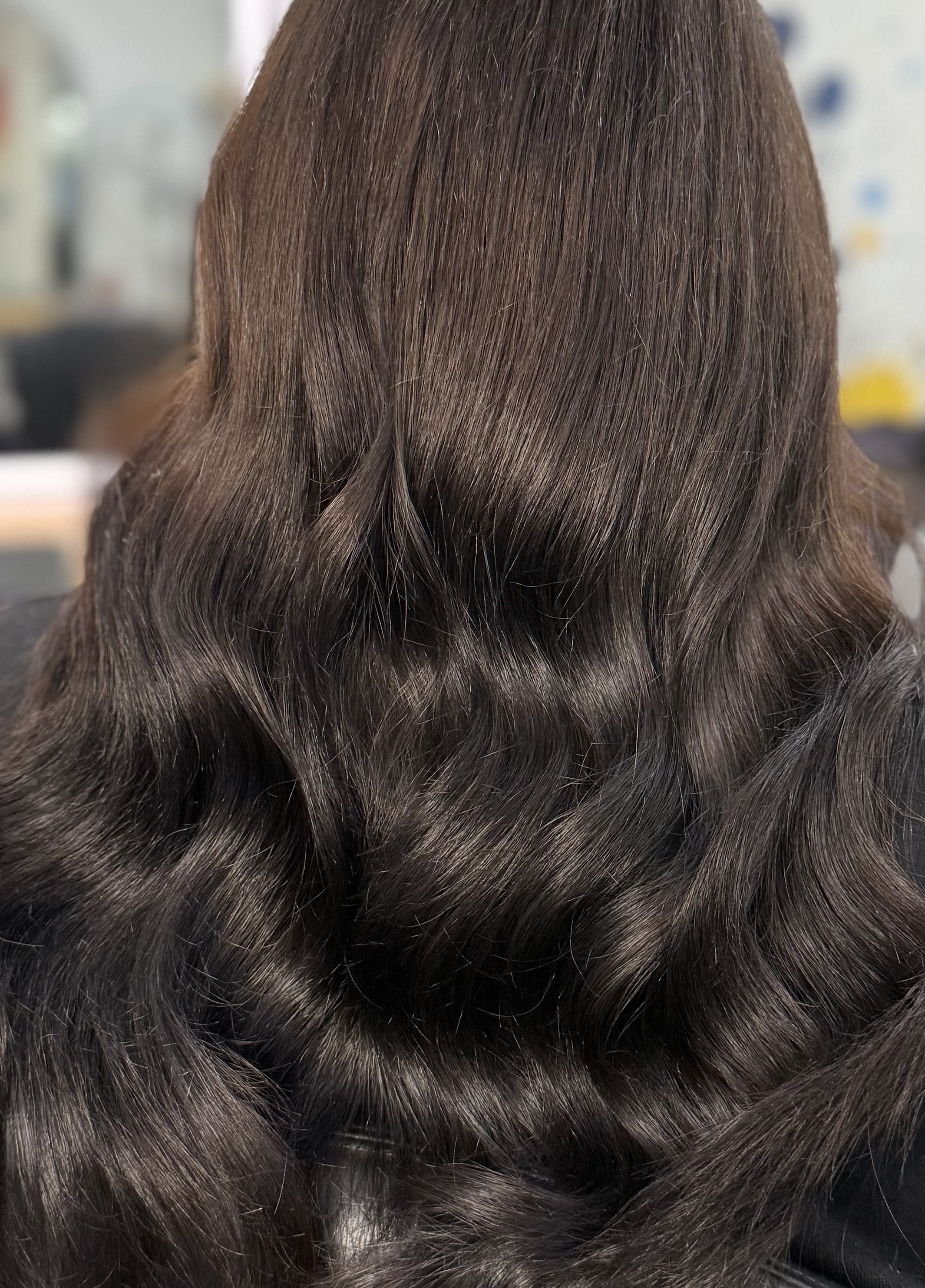 Close-up of dark brown hair with soft waves and shiny strands.