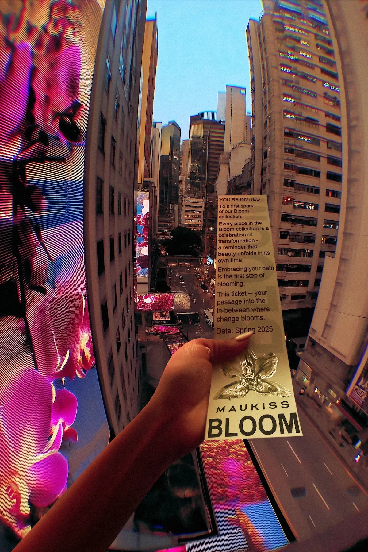 A person's hand holding a ticket labeled 'Maukiss Bloom' in front of a cityscape with tall buildings and large digital screens displaying colorful floral imagery, with a blue sky above.