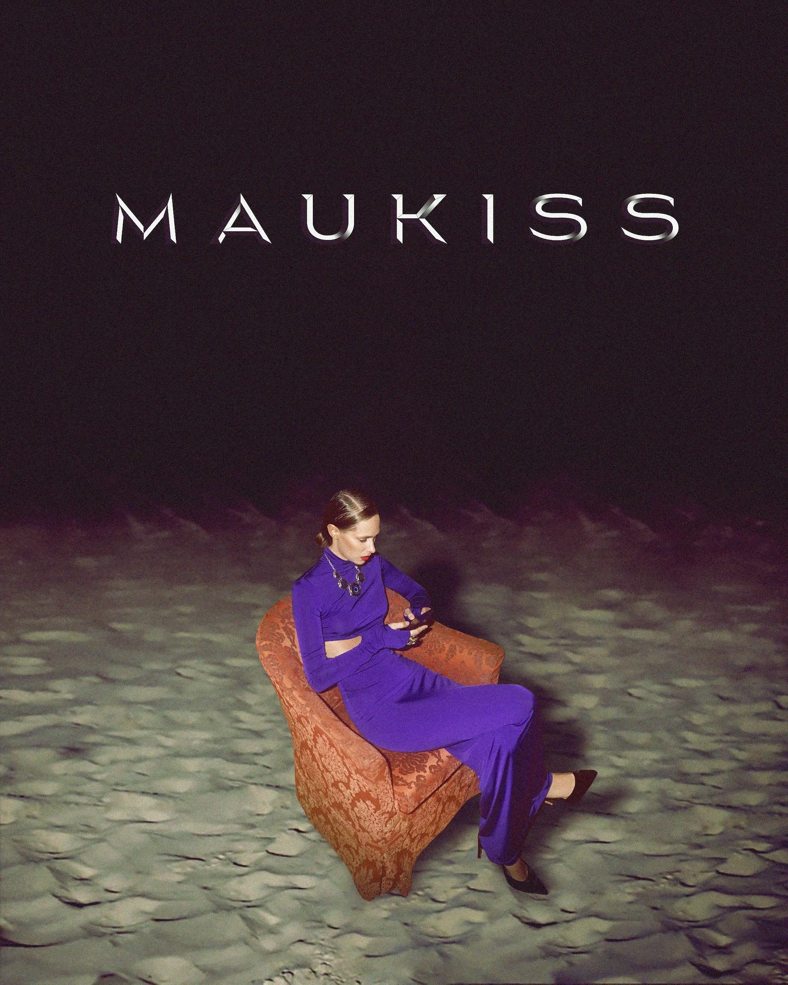 A woman sitting on an ornate chair in the desert at night, looking at her phone. The background is dark with some clouds visible in the sky. The woman is wearing a long purple dress and is looking down at her phone.