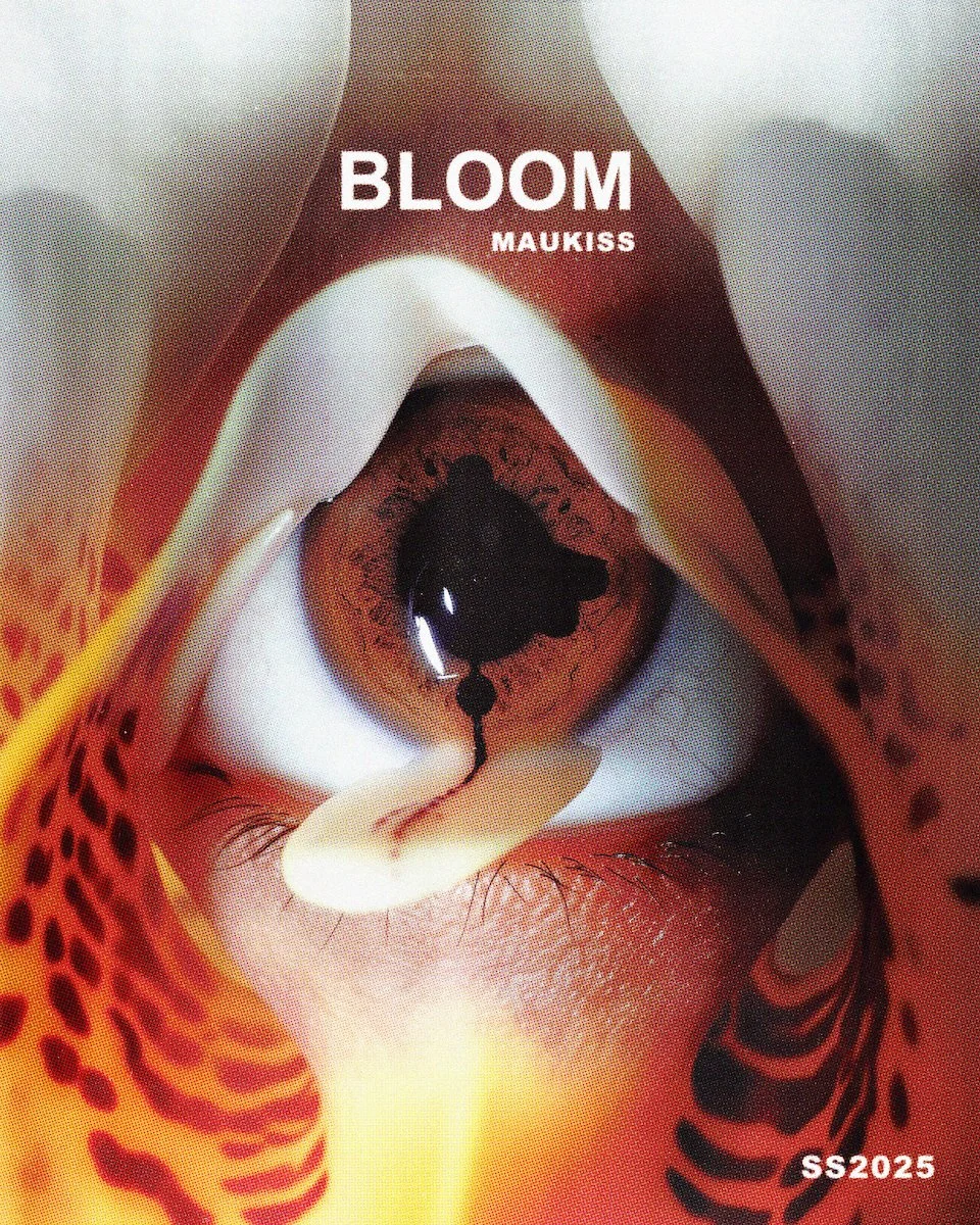 Close-up of a person’s face with makeup and an eye in the center of the forehead, with the text "BLOOM MAUKISS" and "SS2025".