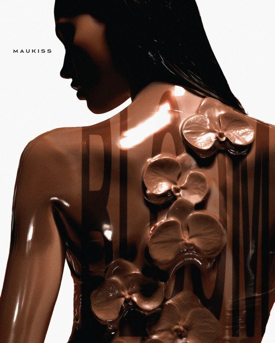 A woman with dark hair and makeup, looking to the side, with shiny, reflective, flower-shaped sculptures and black paint art on her chest and face, against a white background. The word 'MAUKISS' appears in the upper left corner.