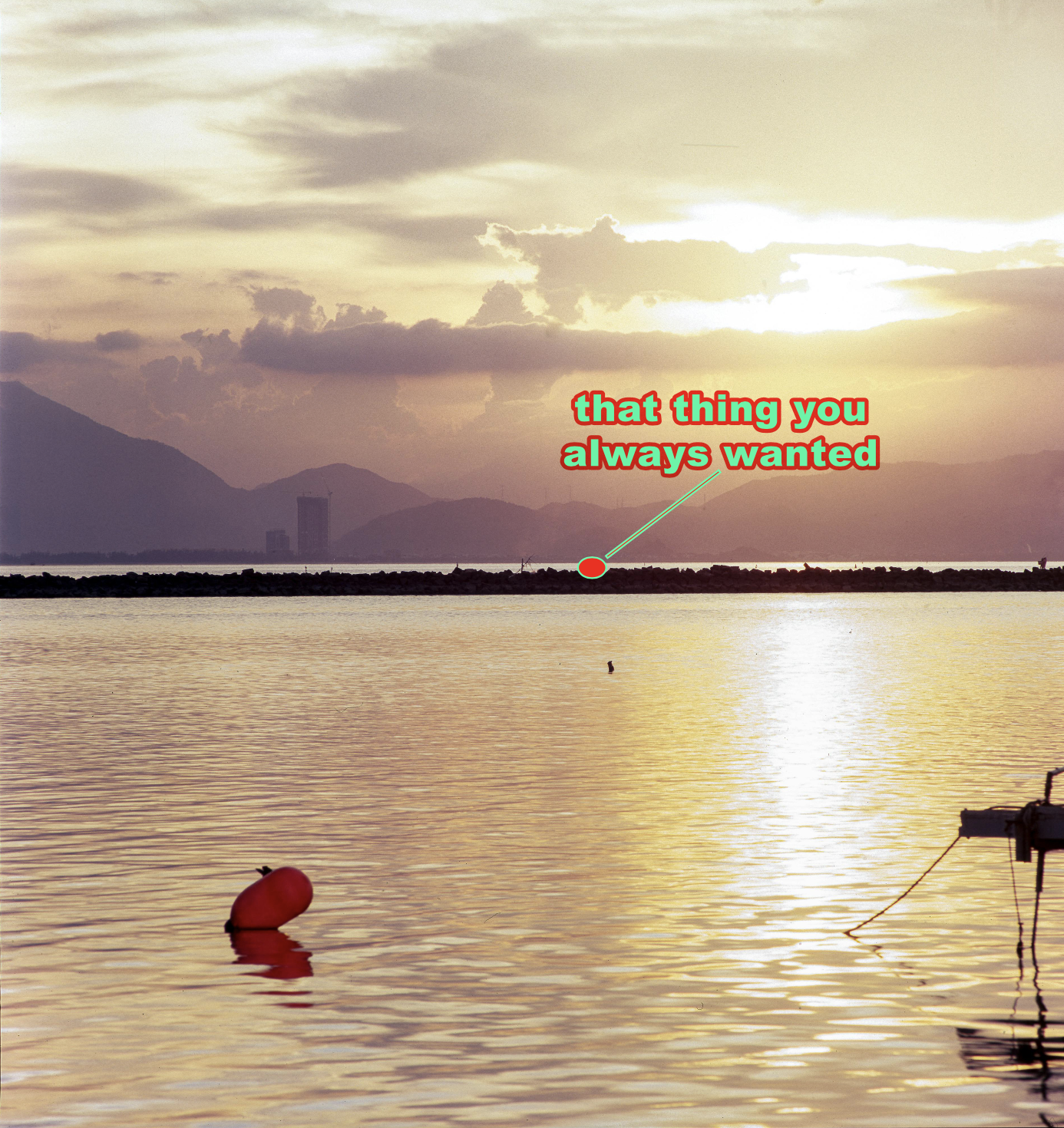 A sunset view over a body of water with mountains in the background, a buoy floating in the water, and a small boat tied to a dock in the lower right corner. The sunset clouds cast a golden hue across the sky and water. Text reading 'that thing you always wanted' is overlaid on the image.