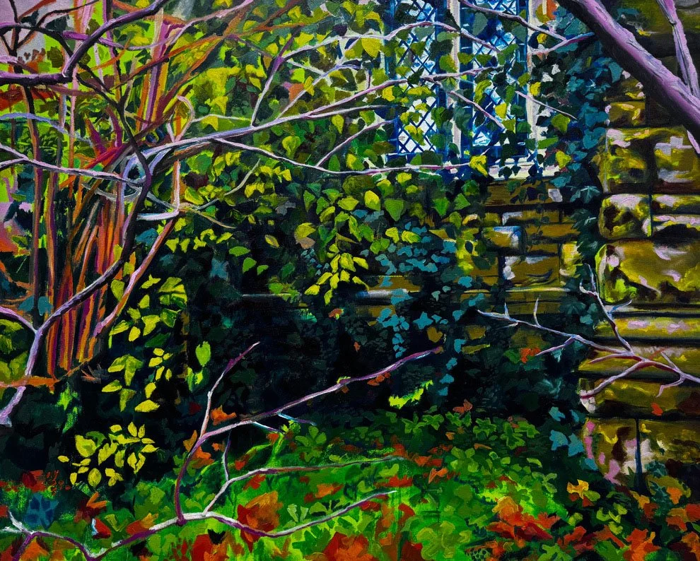 A garden scene with dense green foliage, vines, and branches growing alongside a wooden fence and lattice structure.