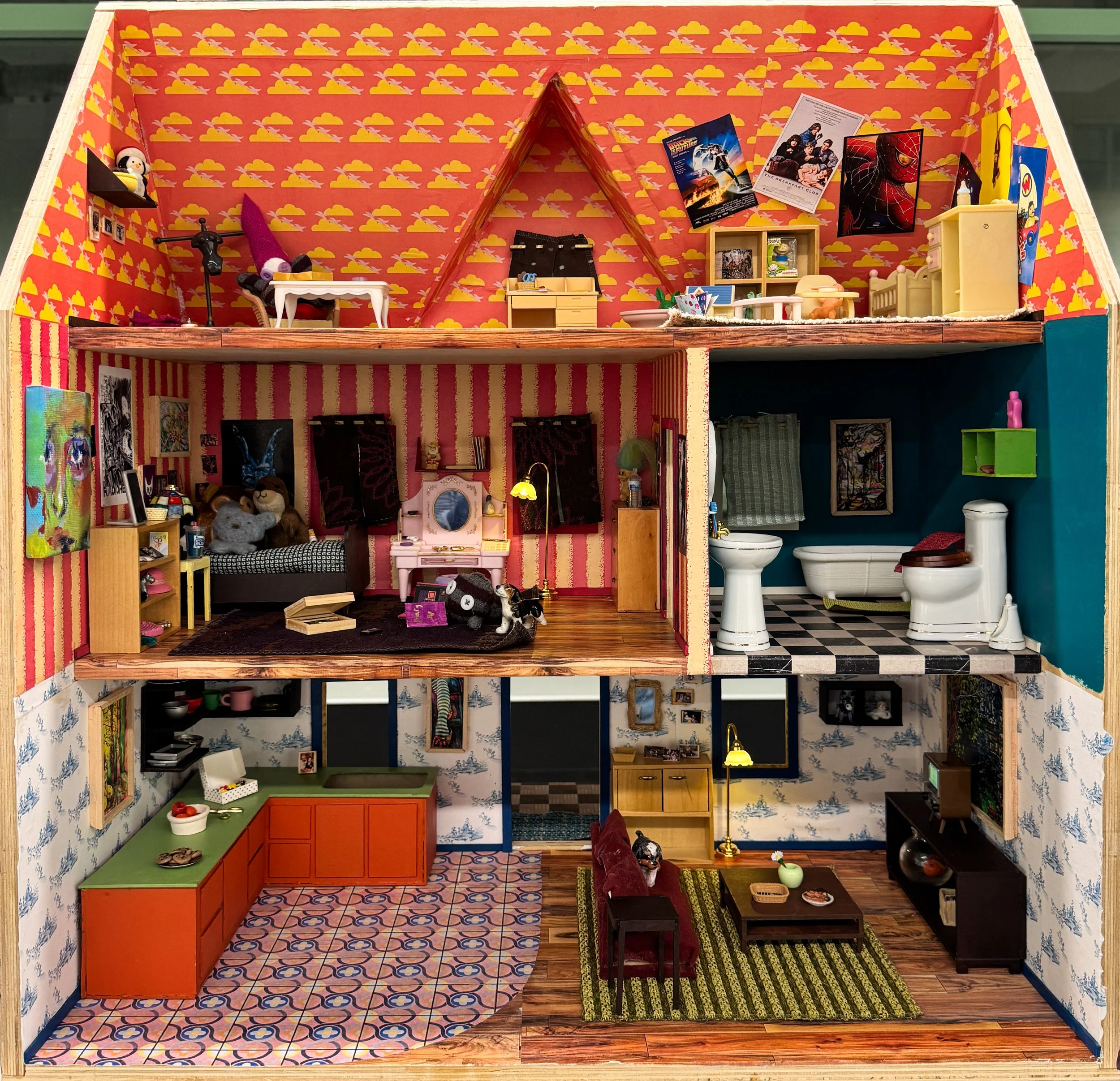 A detailed dollhouse with colorful wallpaper, small furniture, toys, and posters inside. The dollhouse has multiple rooms including a bedroom, bathroom, and living area, with visible decorations and miniature household items.