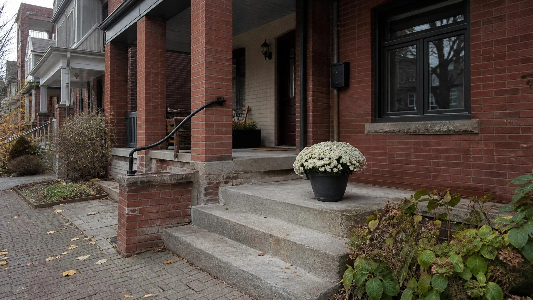 Red brick front porch on a Toronto home with recessed mortar and a spalled corner brick
