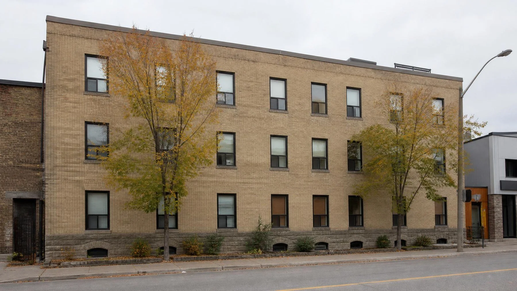 Three storey Toronto brick commercial building with a stone-capped parapet