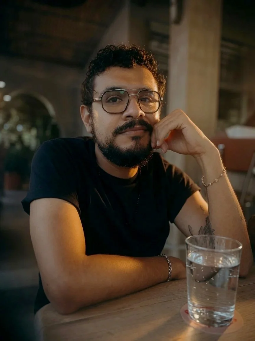 Retrato de Alberto sentado en una mesa , viendo a la cámara con expresión relajada